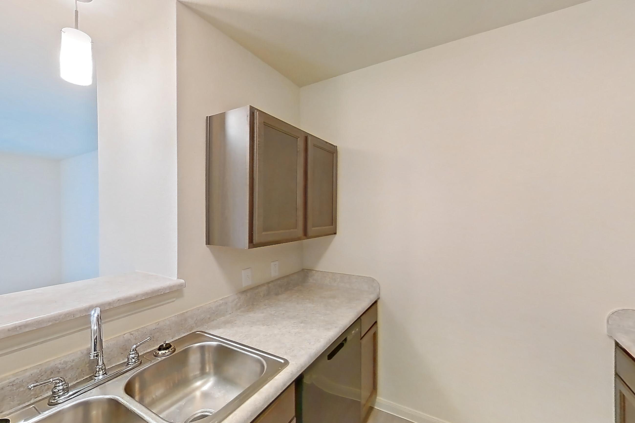 Kitchen with black appliances, dishwasher, electric range, light countertops, light wood-finish flooring, oven/range, refrigerator, and stainless steel appliances, Apartment 10208 at Denton Grove