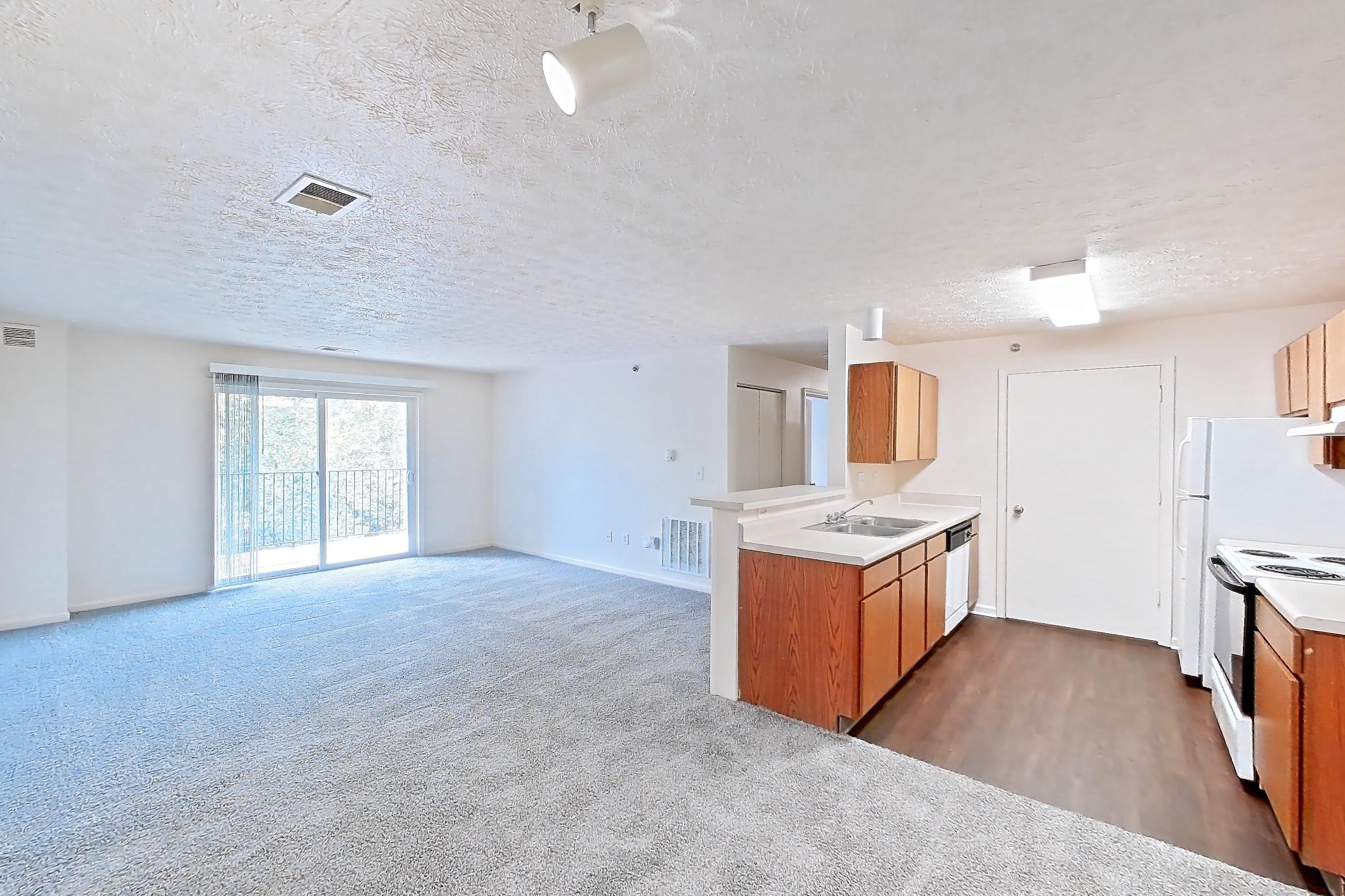 Living space with dark carpet, electric range, light countertops, oven/range, and white appliances, Apartment 8102-K at Crooked Creek