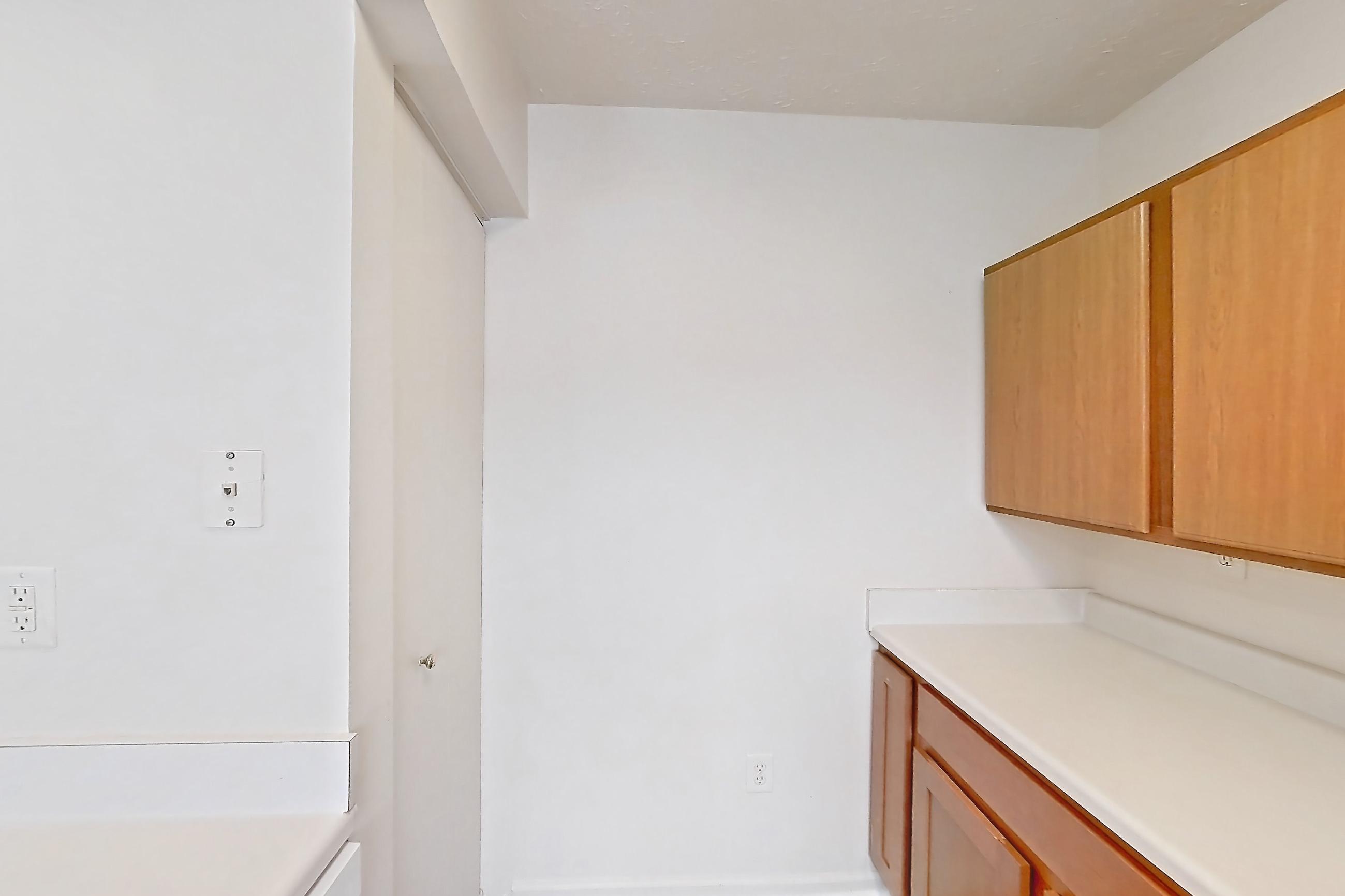 Kitchen with dark wood-finish flooring, dishwasher, electric range, light countertops, oven/range, refrigerator, and white appliances, Apartment 8142-H at Crooked Creek