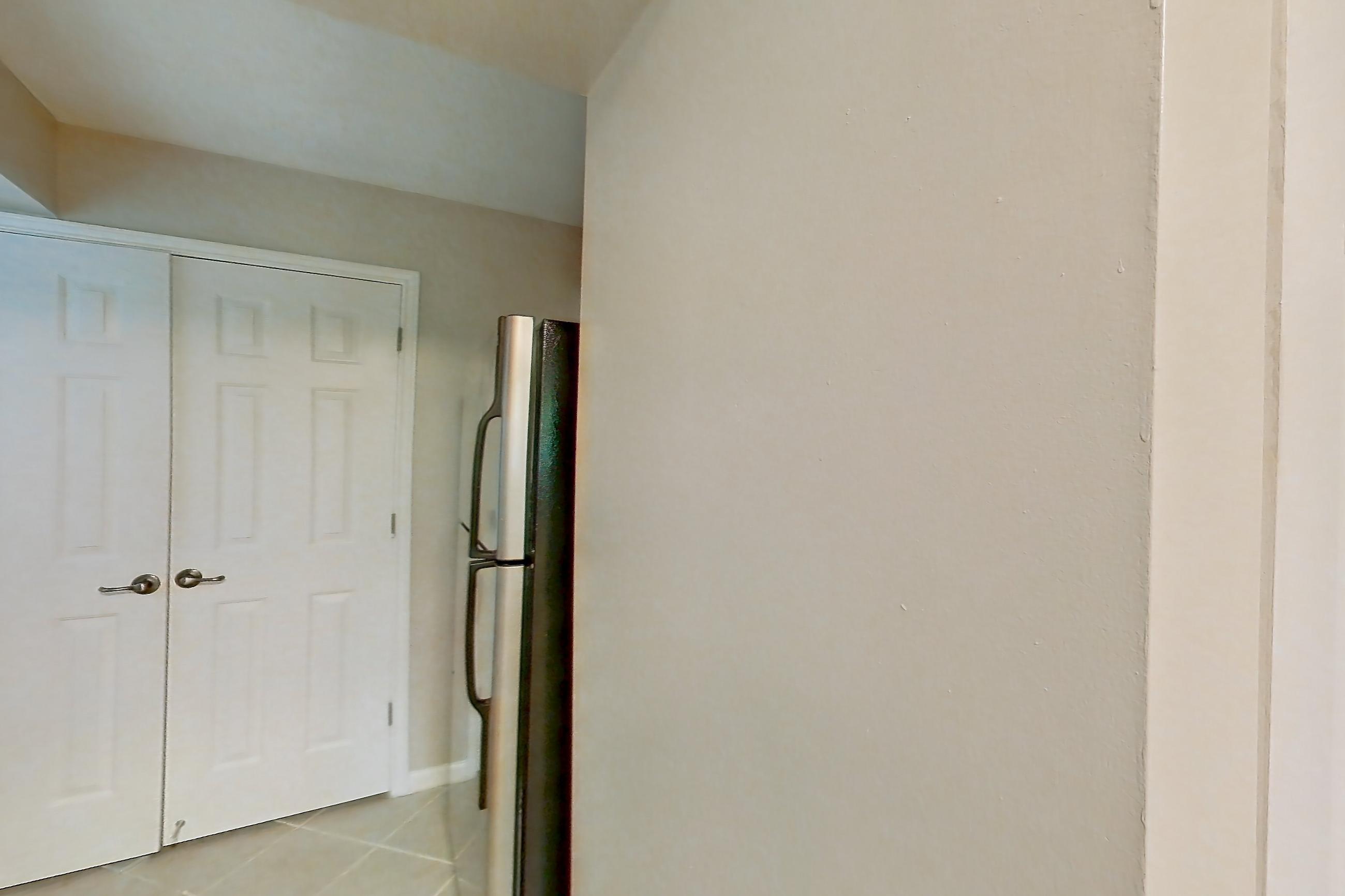 Kitchen with black appliances, dark stone countertops, dishwasher, electric range, light countertops, light tile flooring, microwave, oven/range, refrigerator, and stainless steel appliances, Apartment 3558Q at The Ashford