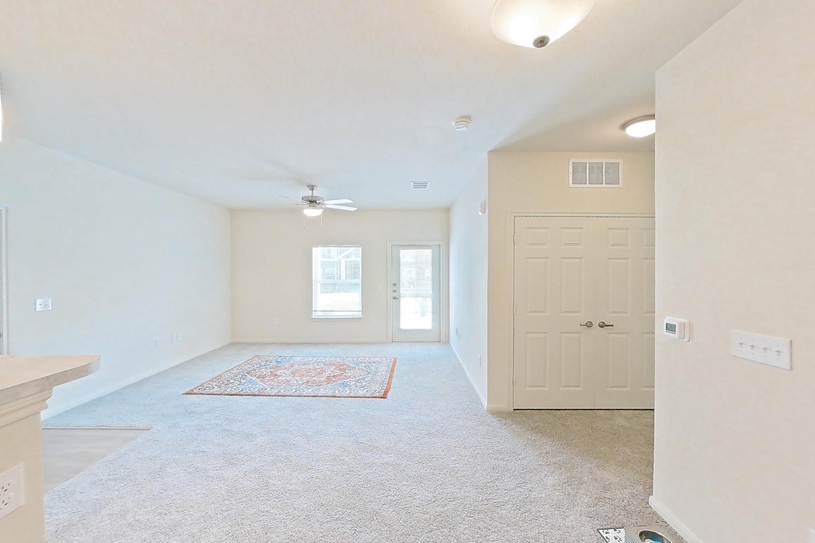 Dining room with black appliances, electric range, light carpet, light countertops, light wood-finish flooring, and oven/range, Apartment 7103 at Mill Stream