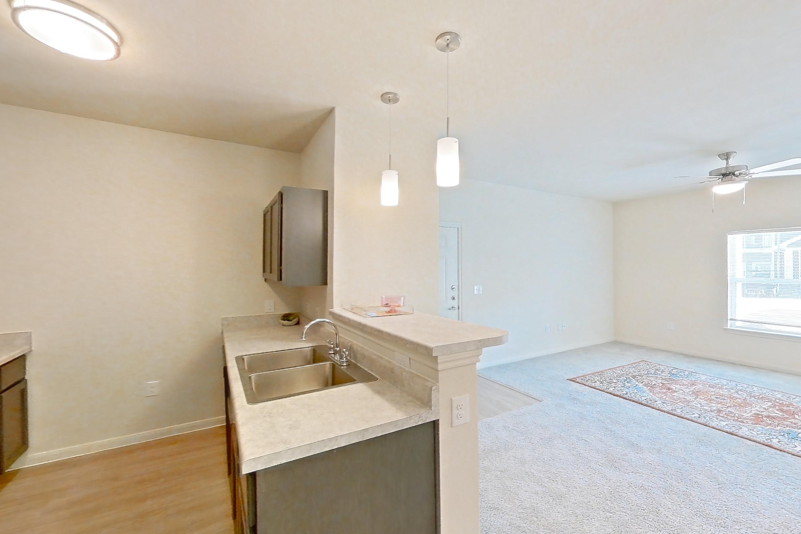Dining room with black appliances, electric range, light carpet, light countertops, light wood-finish flooring, and oven/range, Apartment 7103 at Mill Stream
