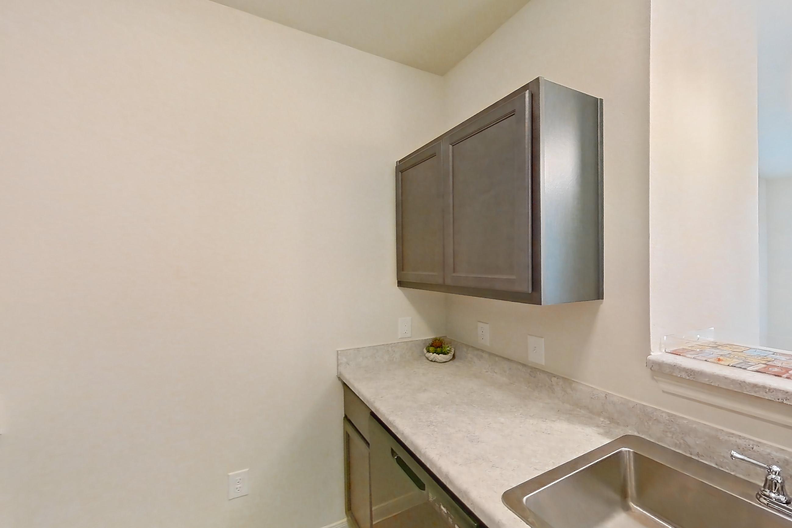 Kitchen with black appliances, dishwasher, electric range, light countertops, light wood-finish flooring, oven/range, refrigerator, and stainless steel appliances, Apartment 7103 at Mill Stream