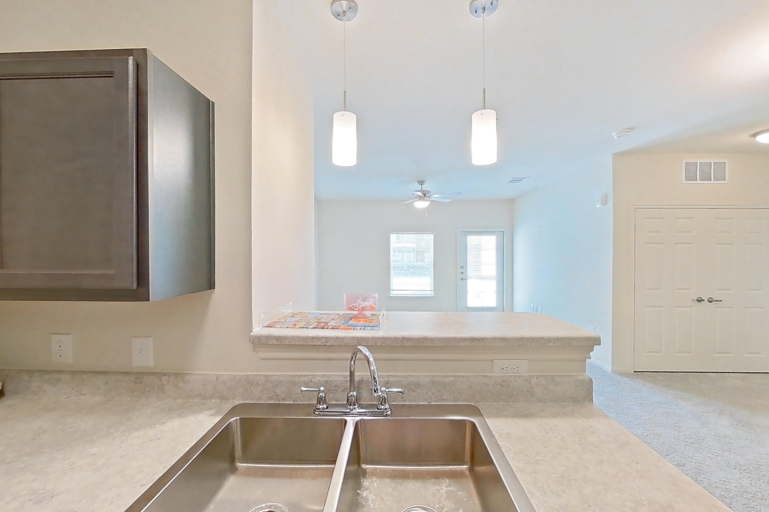 Kitchen with black appliances, dishwasher, electric range, light countertops, light wood-finish flooring, oven/range, refrigerator, and stainless steel appliances, Apartment 7103 at Mill Stream