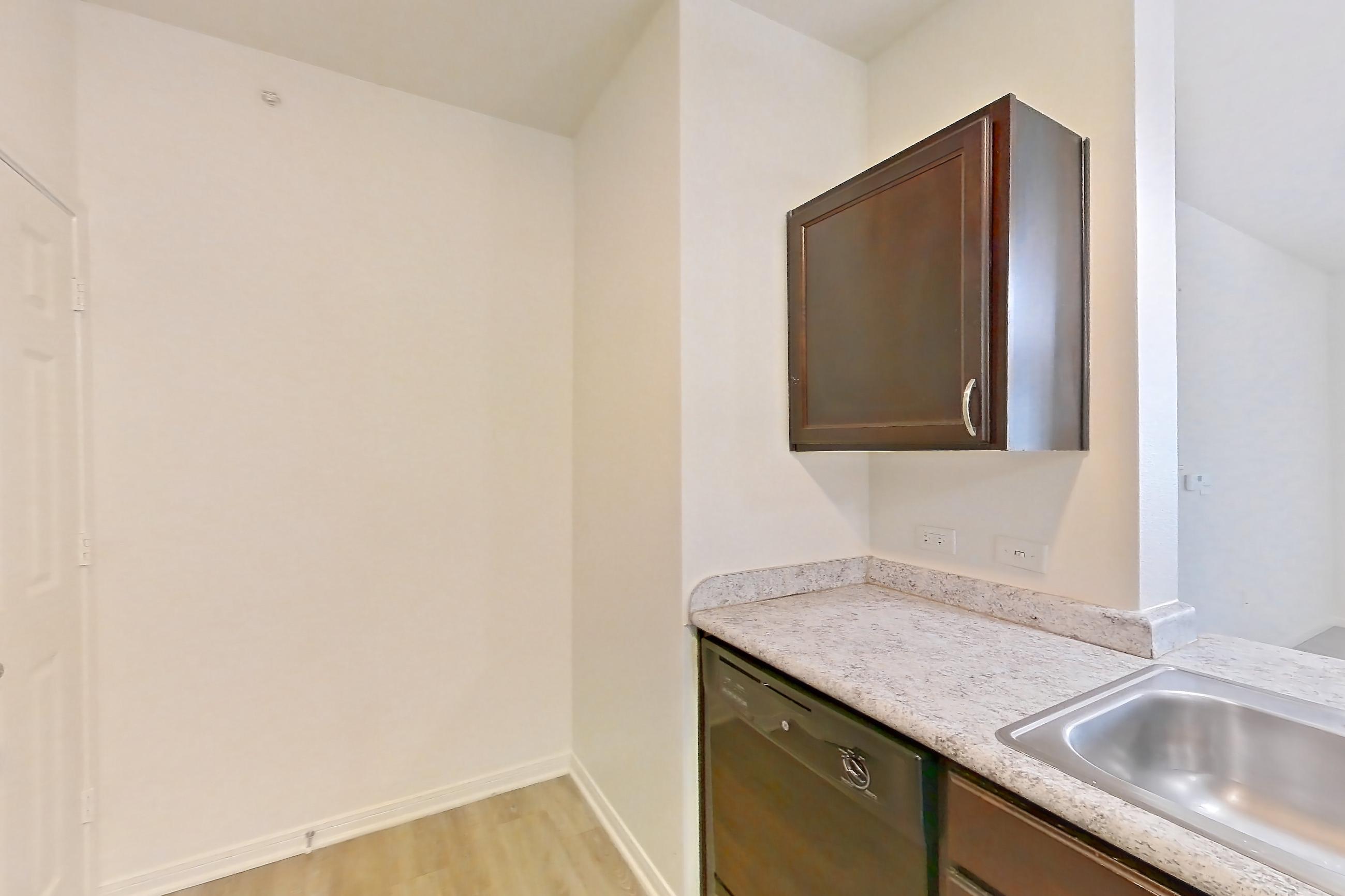 Kitchen with black appliances, dishwasher, electric range, light countertops, light stone countertops, light wood-finish flooring, and oven/range, Apartment 632 at Tuckaway