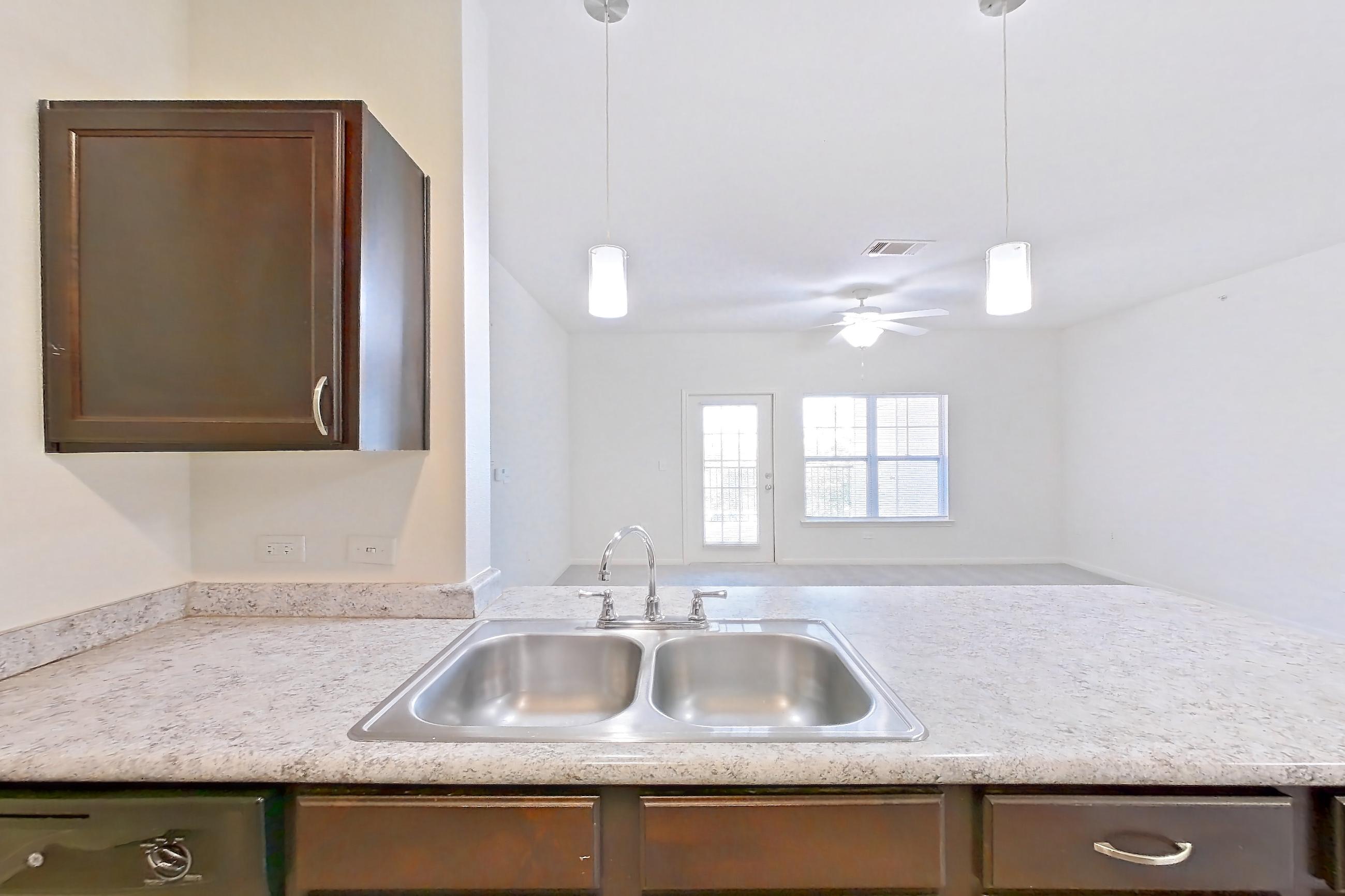 Kitchen with black appliances, dishwasher, electric range, light countertops, light stone countertops, light wood-finish flooring, and oven/range, Apartment 632 at Tuckaway