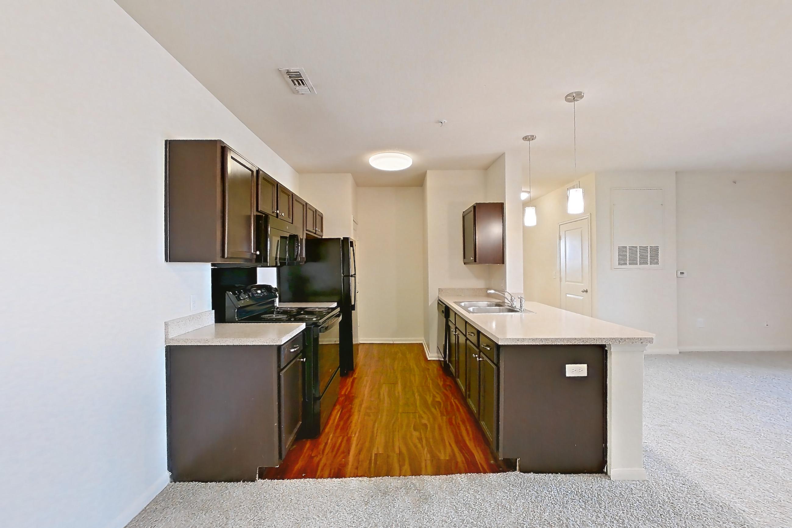 Dining space with black appliances, dark carpet, electric range, light countertops, microwave, oven/range, refrigerator, and stainless steel appliances, Apartment 1033 at The Heights on Parmer