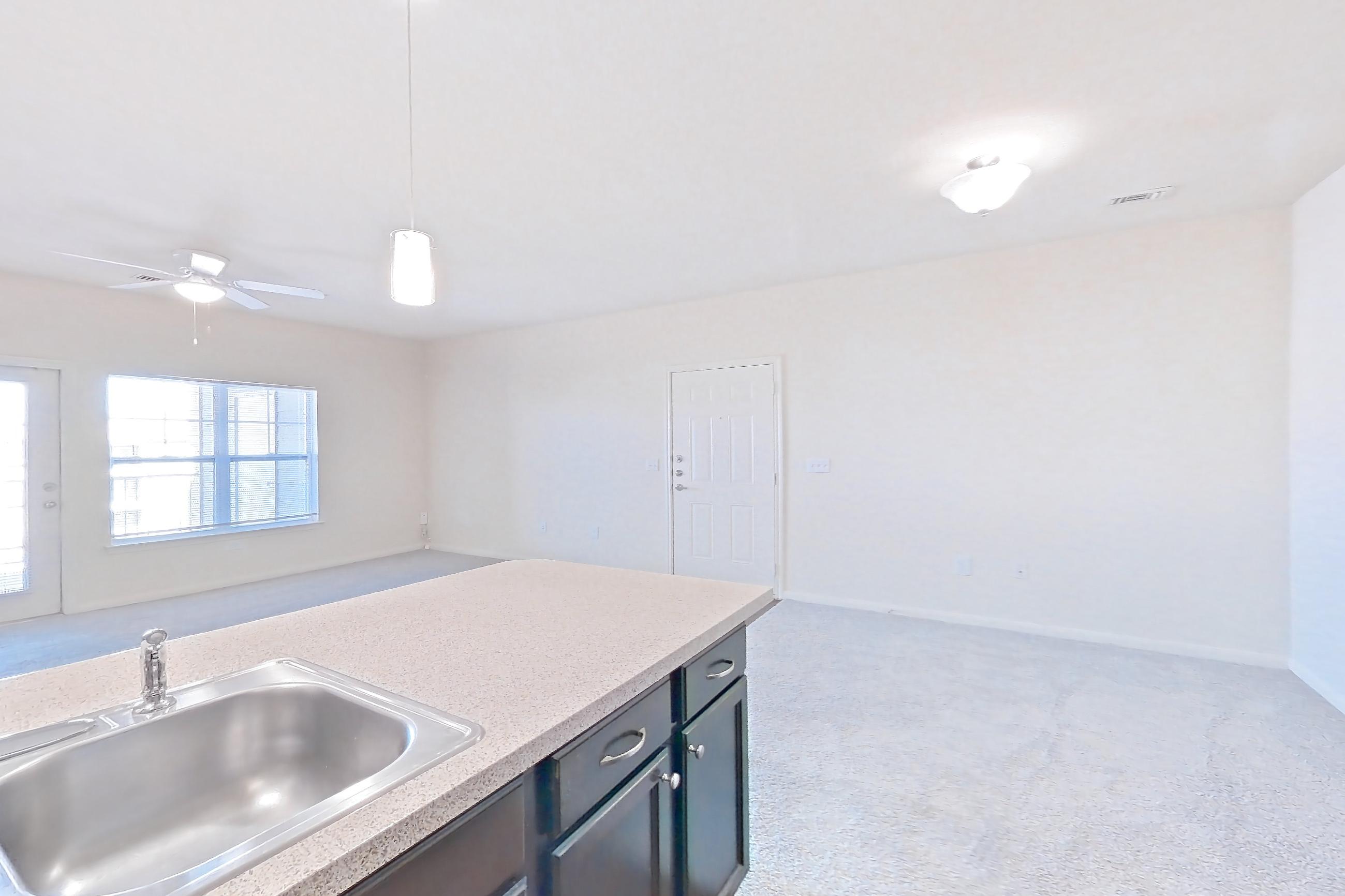 Kitchen with black appliances, dark carpet, dark wood-finish flooring, dishwasher, electric range, light countertops, light stone countertops, oven/range, refrigerator, and stainless steel appliances, Apartment 1033 at The Heights on Parmer