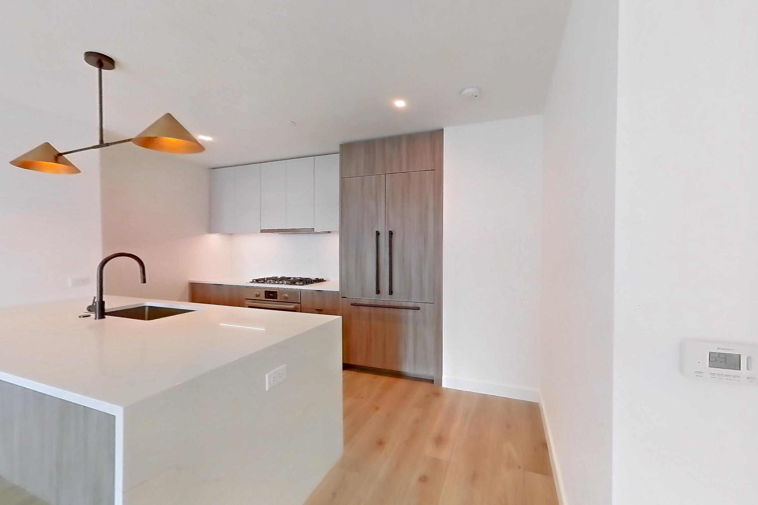 Living space with cooktop, gas cooktop, light stone countertops, light wood-finish flooring, and stainless steel appliances, Apartment 08B at Maison 78