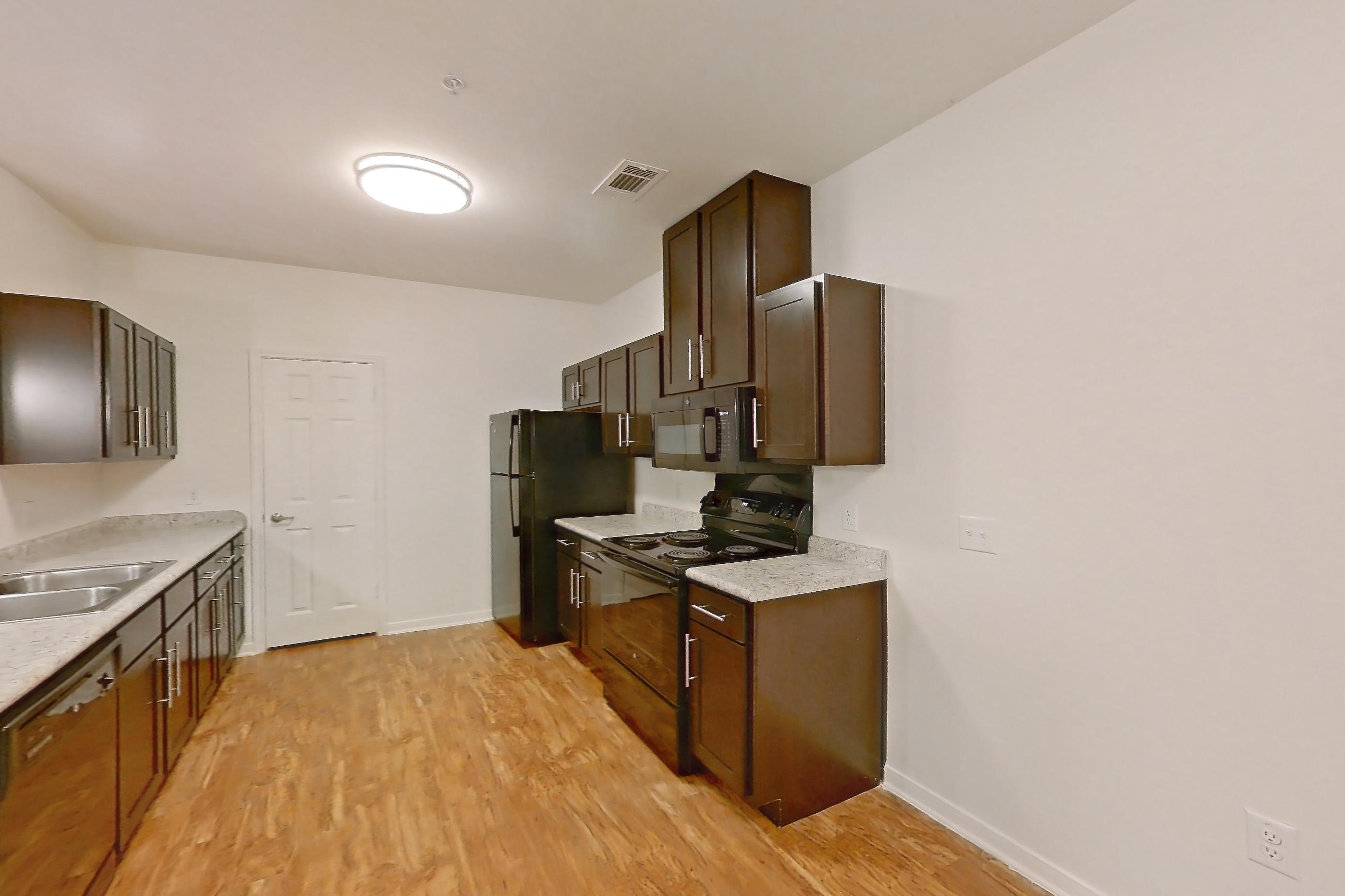 Dining room with black appliances, electric range, light countertops, light wood-finish flooring, oven/range, and refrigerator, Apartment 1204 at Oak Valley