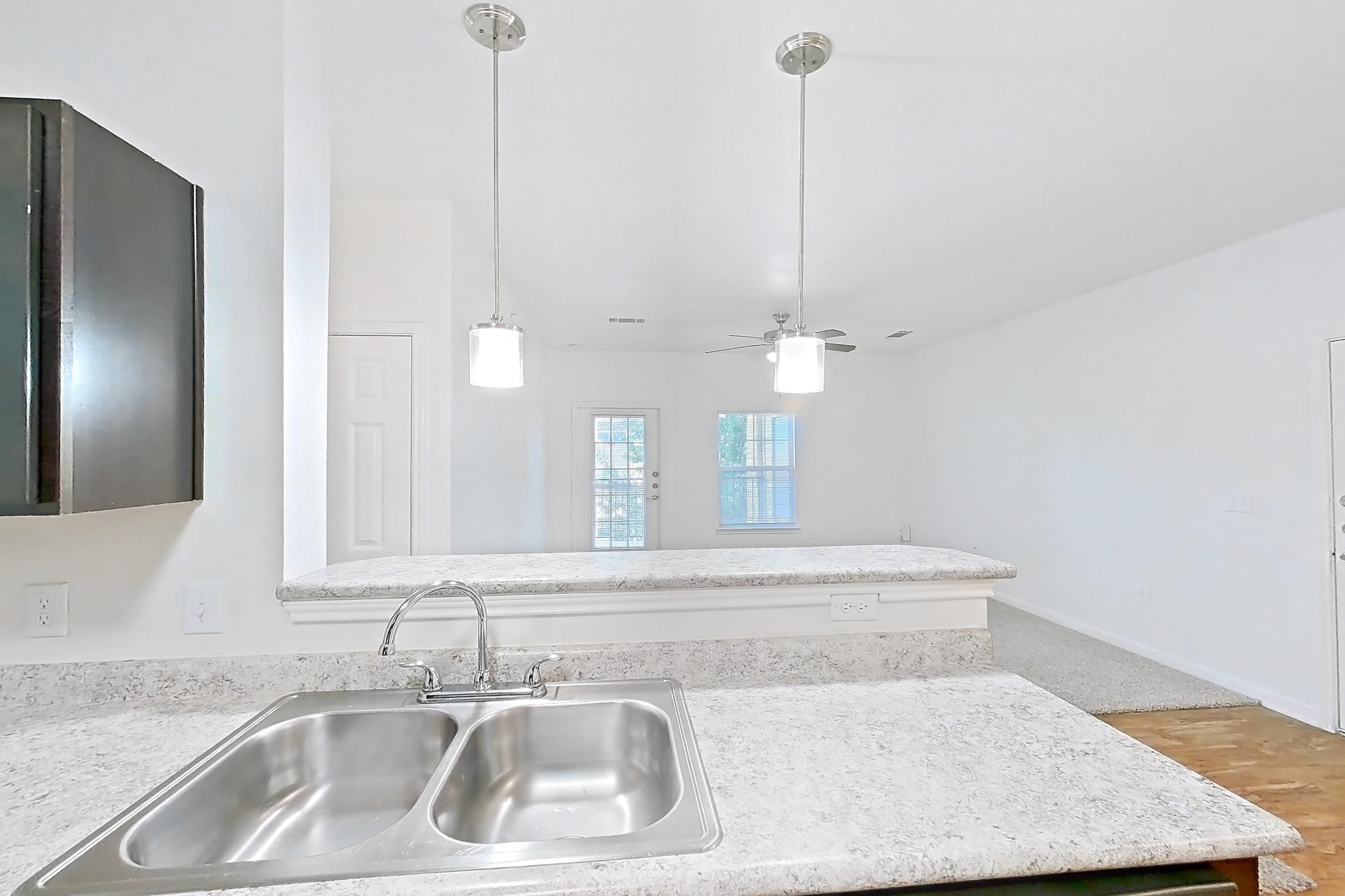 Kitchen with black appliances, dishwasher, electric range, light countertops, light stone countertops, light wood-finish flooring, oven/range, and refrigerator, Apartment 7202 at Oak Valley