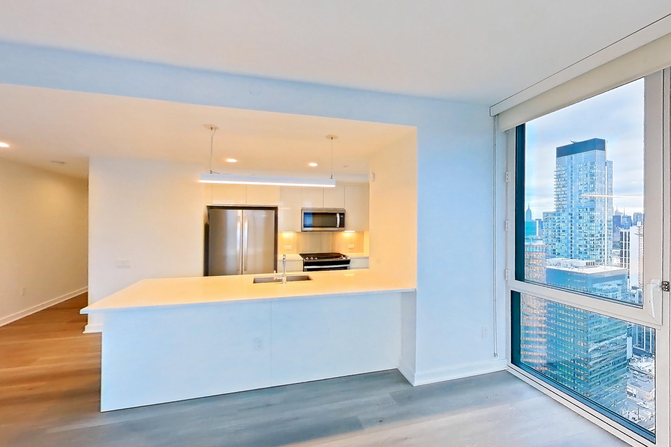 Living space with city view, light countertops, and light wood-finish flooring, Apartment Ph2B at Alta+