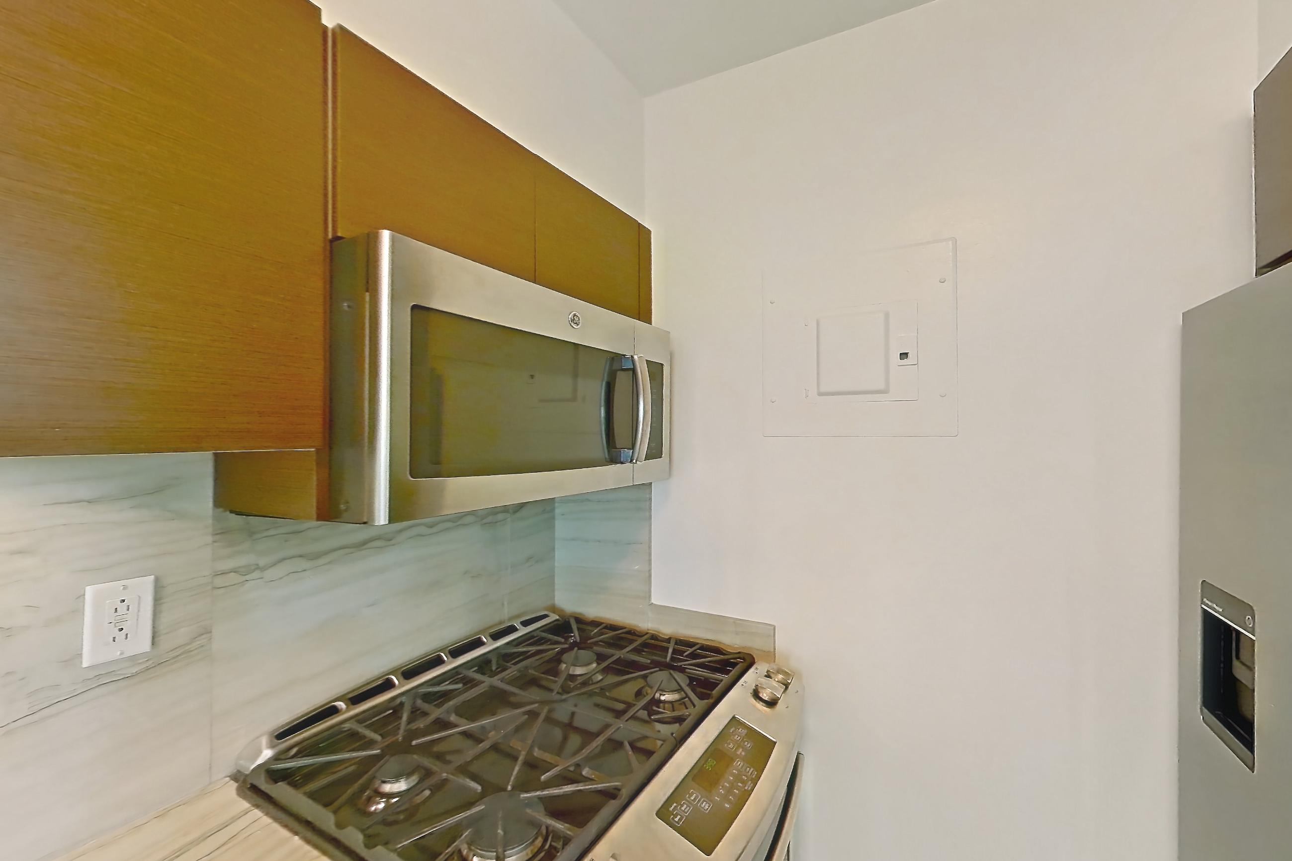Kitchen with gas range, light stone countertops, light tile flooring, microwave, oven/range, and stainless steel appliances, Apartment 3A at Stonehenge Leasing