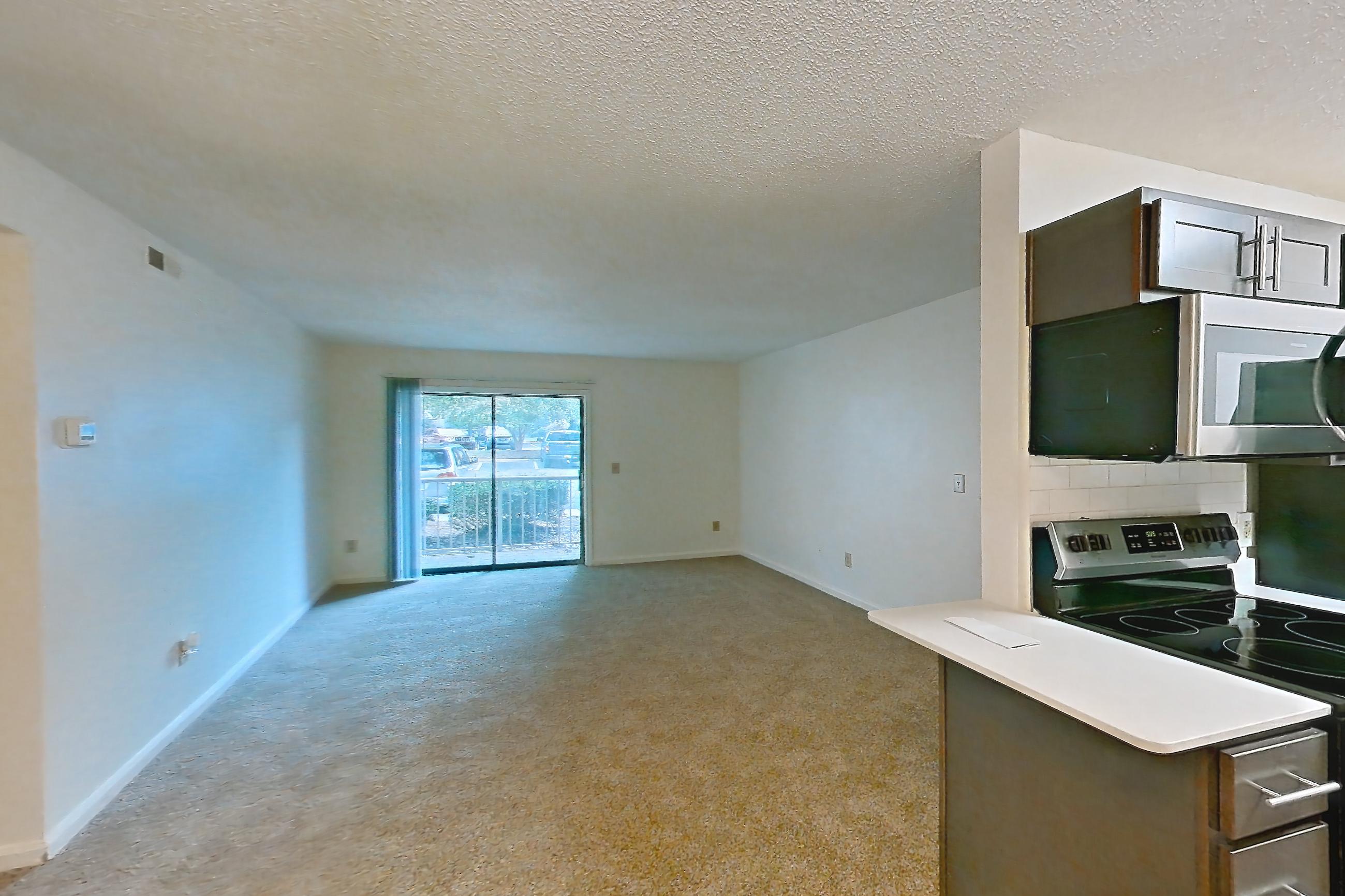 Dining room with dark carpet, dark wood-finish flooring, electric range, light stone countertops, microwave, oven/range, refrigerator, and stainless steel appliances, Apartment 15106 at The Boulders