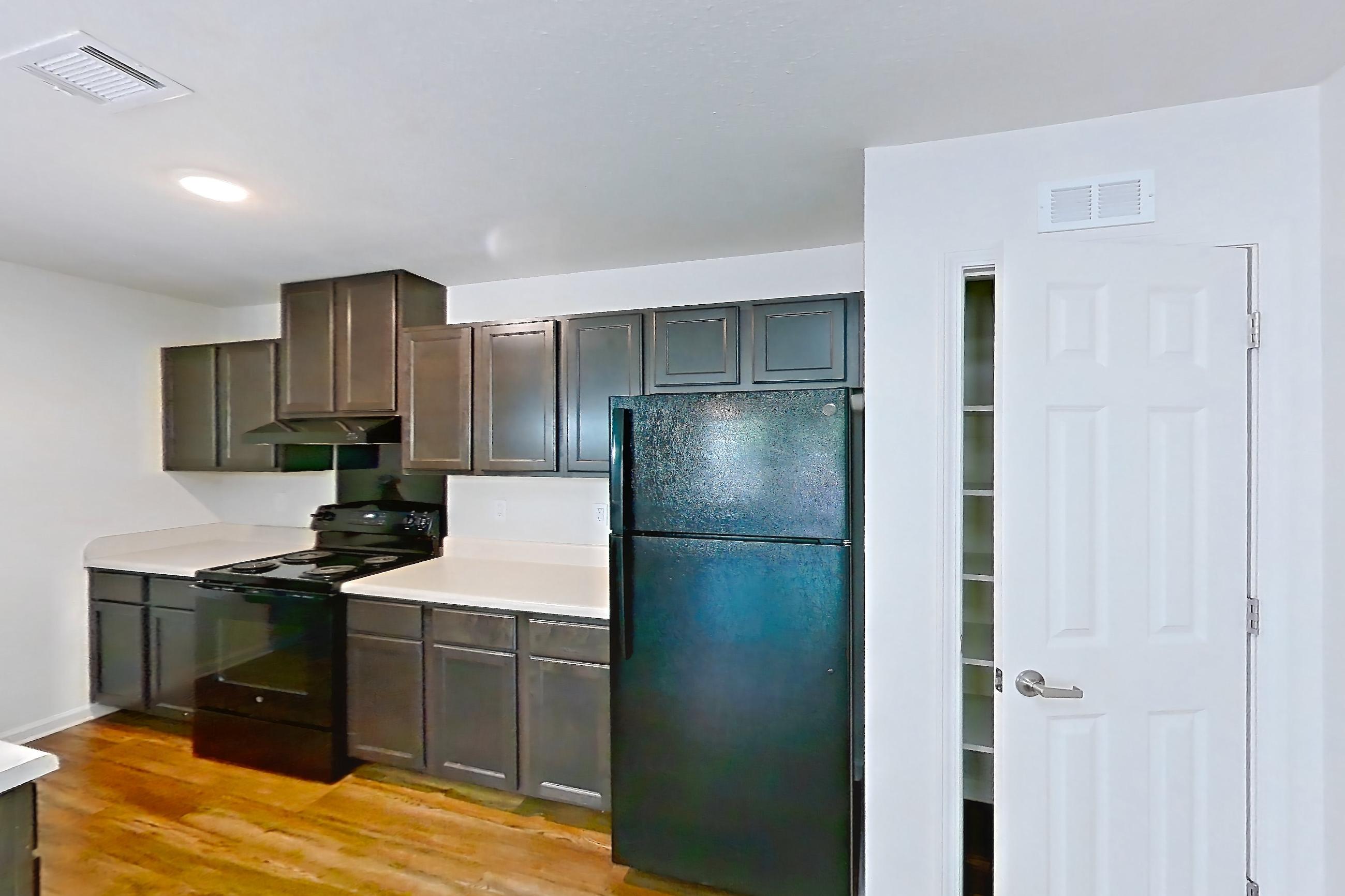 Dining room with black appliances, dark wood-finish flooring, electric range, light countertops, oven/range, and refrigerator, Apartment 8223 Unit 108 at The HUB on Harris