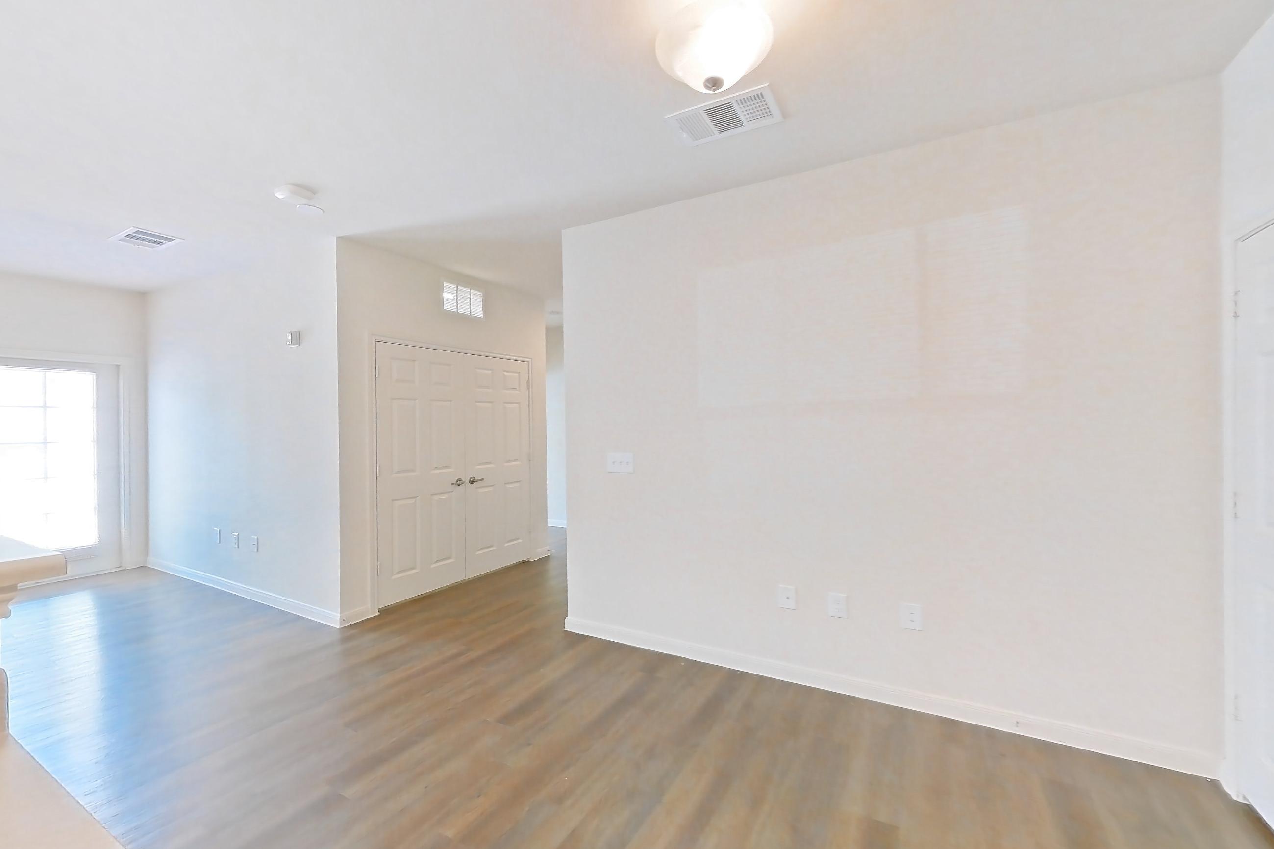 Kitchen with black appliances, dark wood-finish flooring, dishwasher, light countertops, light wood-finish flooring, microwave, oven/range, refrigerator, and stainless steel appliances, Apartment 11105 at Canyon Pass
