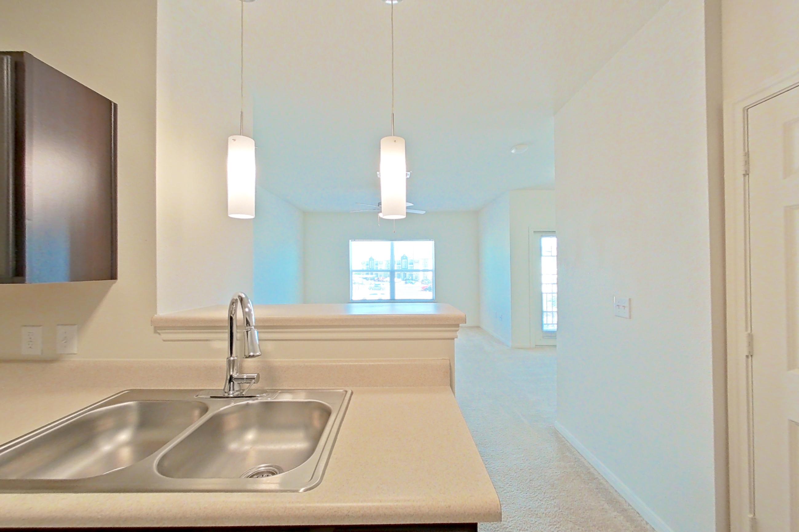Kitchen with black appliances, dishwasher, electric range, light countertops, light wood-finish flooring, oven/range, refrigerator, and stainless steel appliances, Apartment 9301 at Canyon Pass
