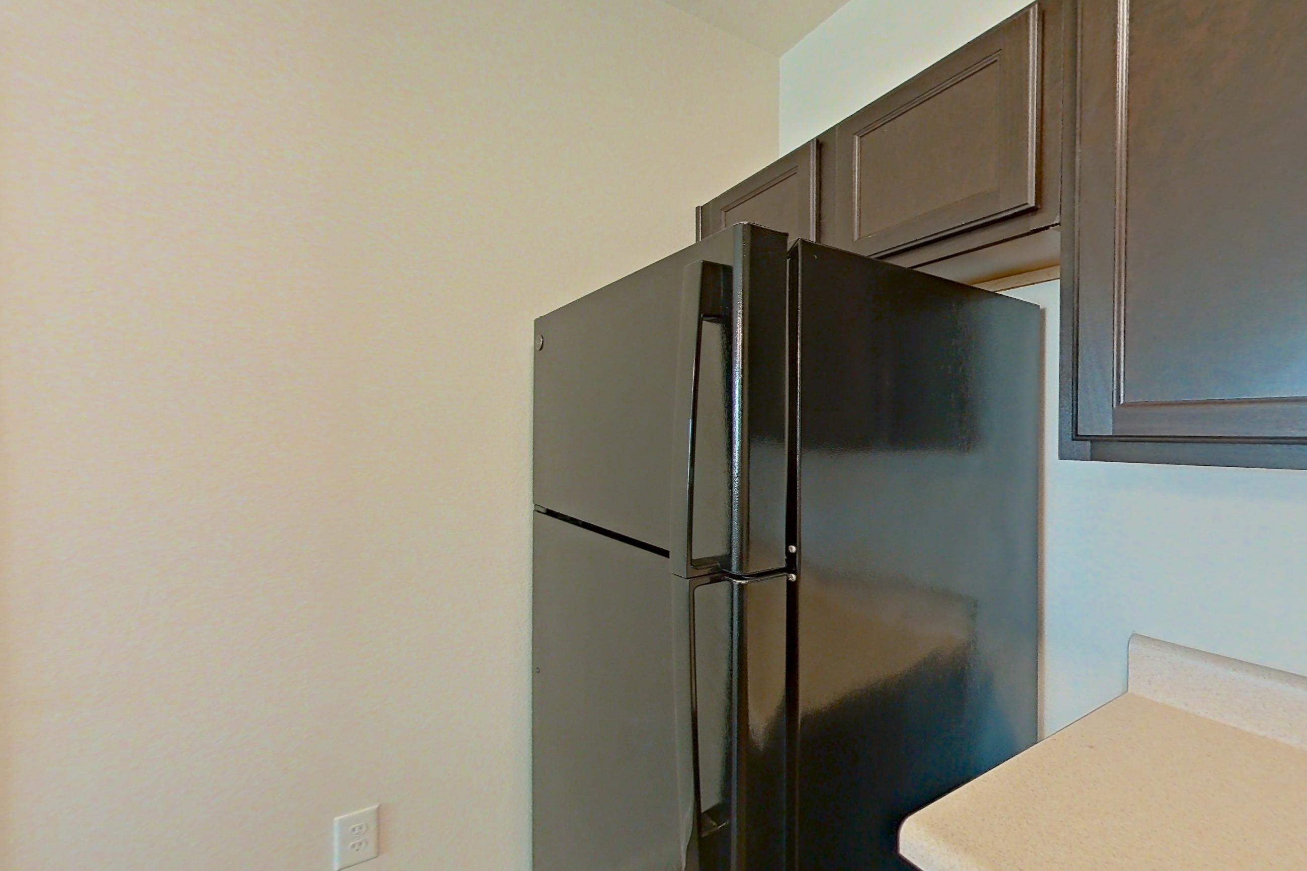 Kitchen with black appliances, dishwasher, electric range, light countertops, light wood-finish flooring, oven/range, refrigerator, and stainless steel appliances, Apartment 9301 at Canyon Pass