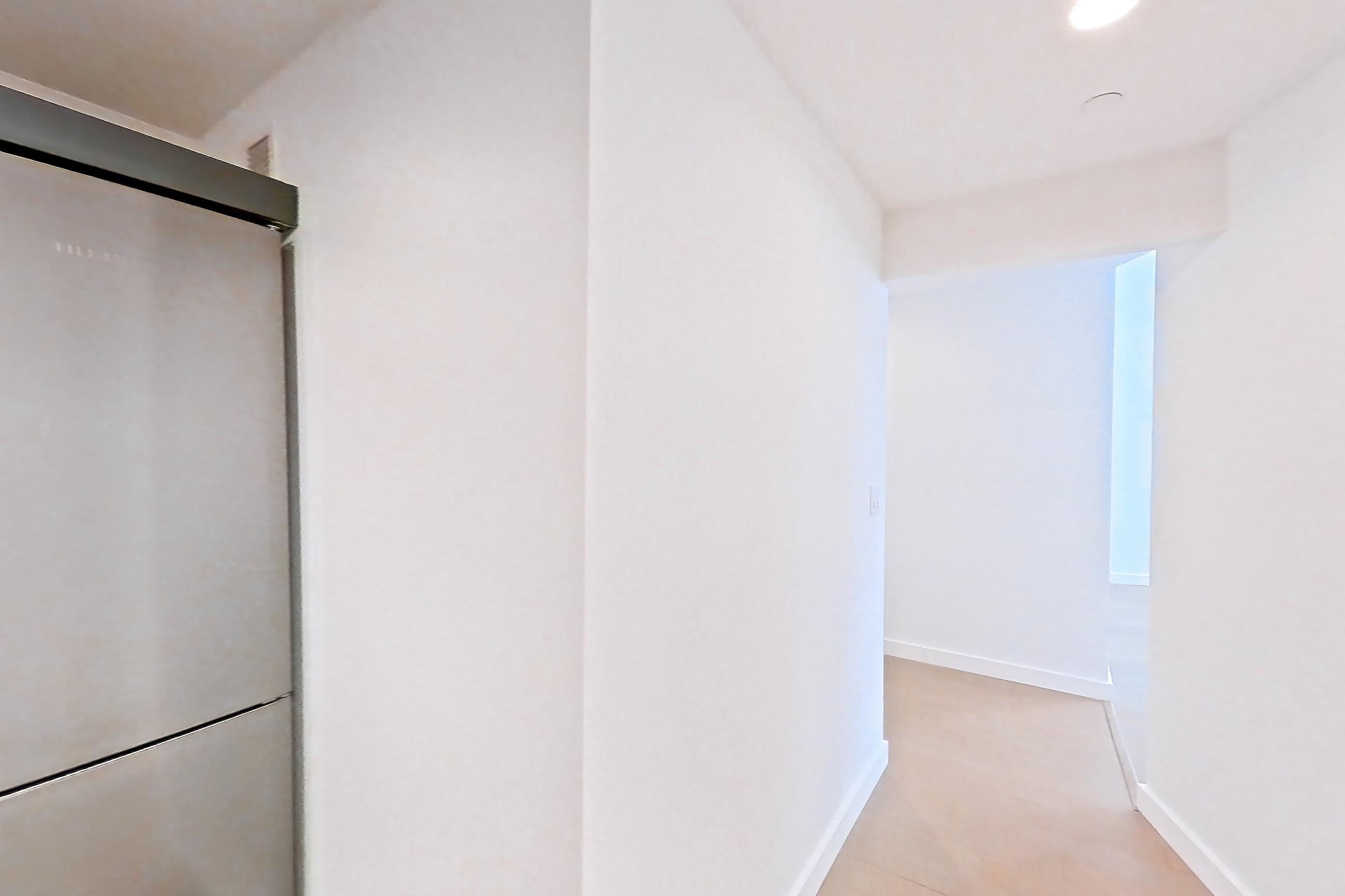 Kitchen with dark countertops, dark stone countertops, electric range, light wood-finish flooring, microwave, refrigerator, and stainless steel appliances, Apartment 1503 at 20 Exchange Place