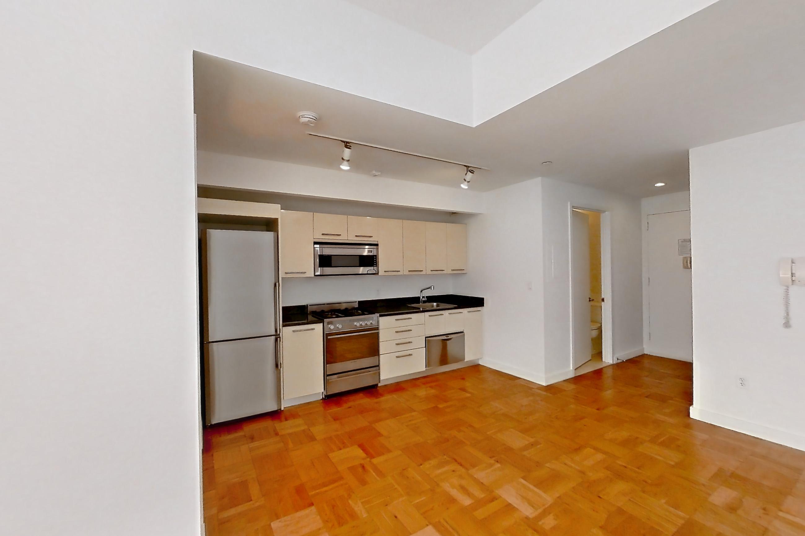 Living room with dark countertops, gas range, light wood-finish flooring, oven/range, parquet flooring, refrigerator, stainless steel appliances, and white appliances, Apartment 2104 at 20 Exchange Place