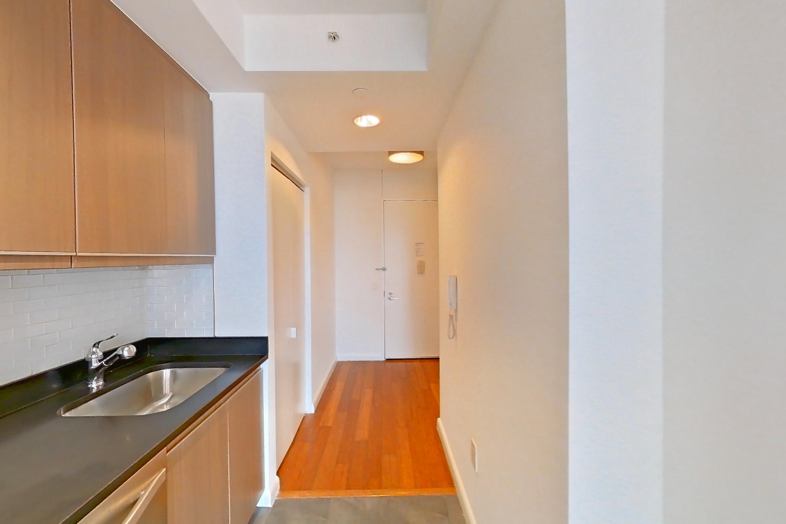 Kitchen with dark countertops, dishwasher, gas range, light countertops, light tile flooring, microwave, oven/range, refrigerator, stainless steel appliances, and white appliances, Apartment 24F at 66 Rockwell
