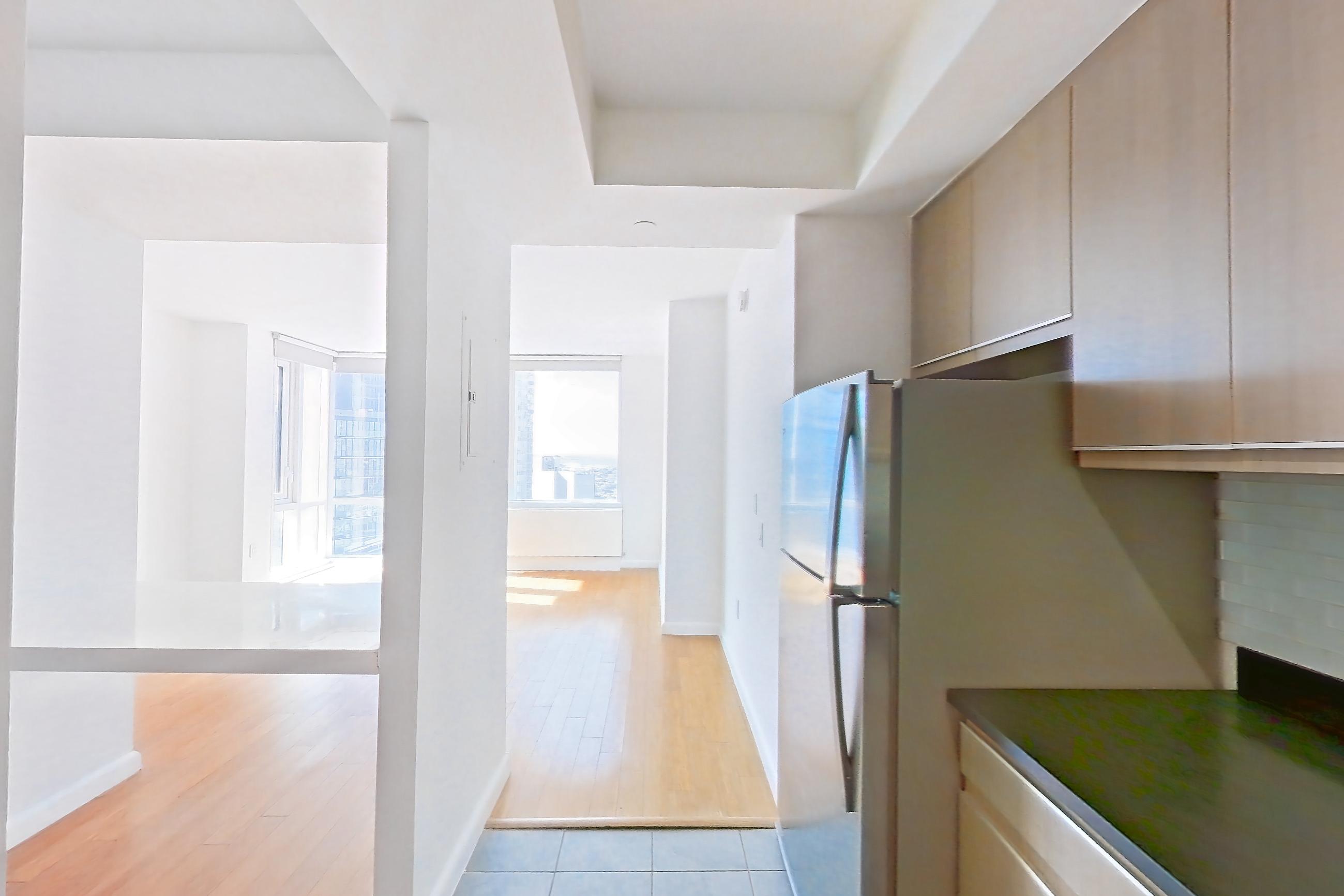 Kitchen with dark countertops, dishwasher, gas range, light countertops, light tile flooring, microwave, oven/range, refrigerator, stainless steel appliances, and white appliances, Apartment 24F at 66 Rockwell