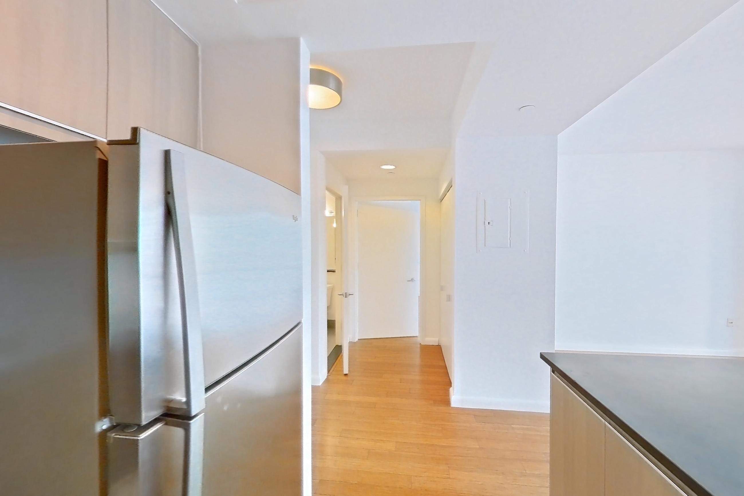 Kitchen with dark countertops, dishwasher, gas range, light tile flooring, microwave, oven/range, refrigerator, and stainless steel appliances, Apartment 25A at 66 Rockwell