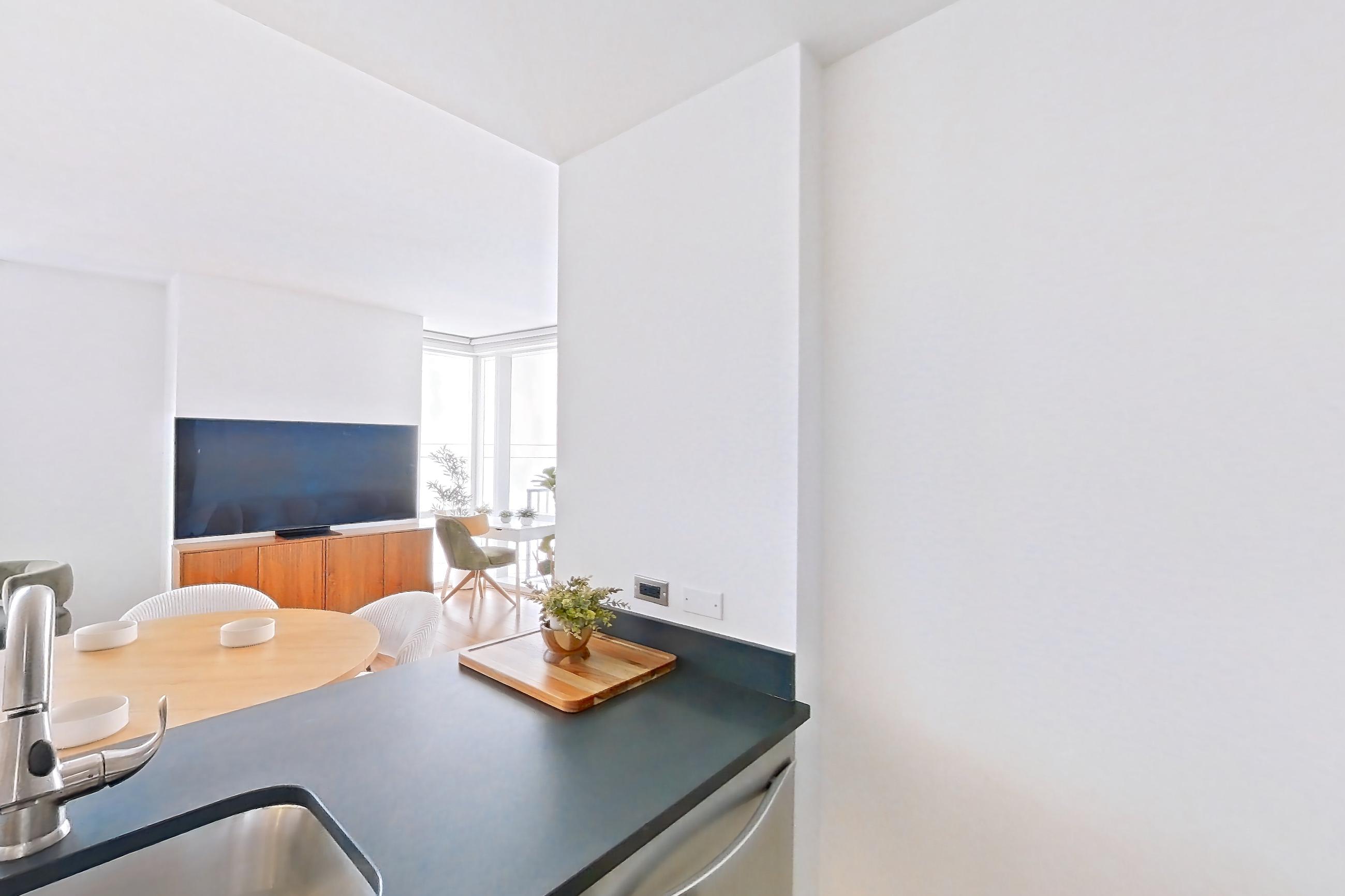 Kitchen with dark countertops, dark tile flooring, dishwasher, gas range, light countertops, light tile flooring, microwave, oven/range, refrigerator, and stainless steel appliances, Apartment 18J at 66 Rockwell