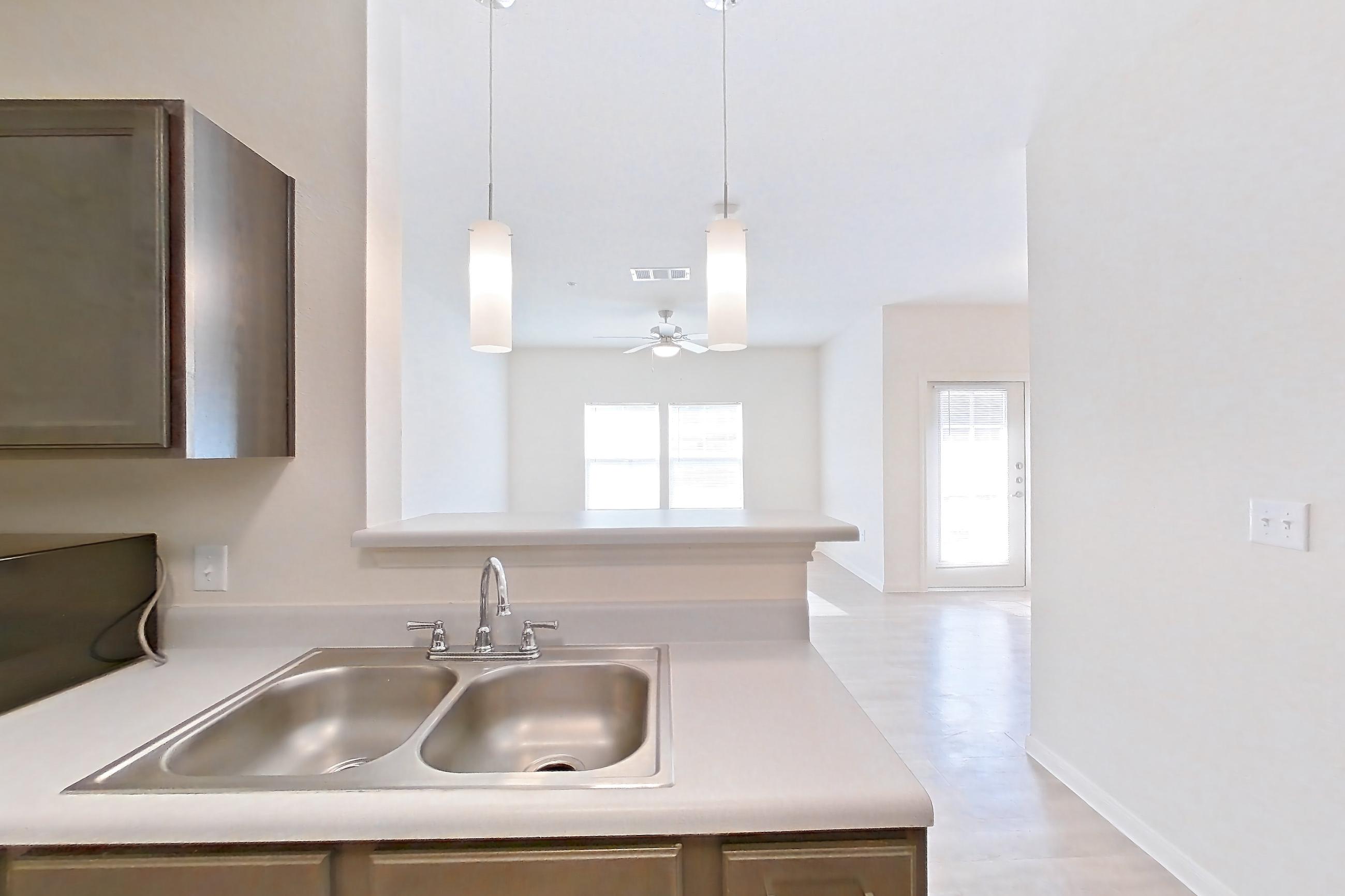 Kitchen with black appliances, light countertops, light wood-finish flooring, microwave, oven/range, and refrigerator, Apartment 10101 at Crosswinds