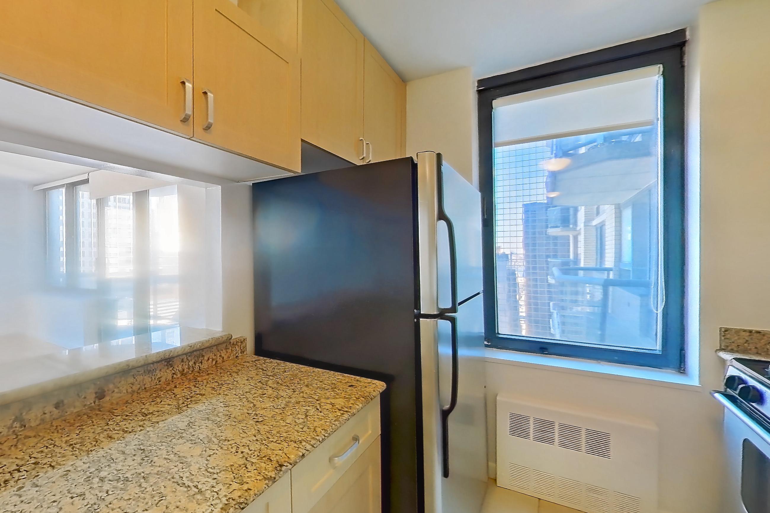 Kitchen with dishwasher, gas range, light stone countertops, light tile flooring, microwave, oven/range, refrigerator, and stainless steel appliances, Apartment 36M at Stonehenge Leasing