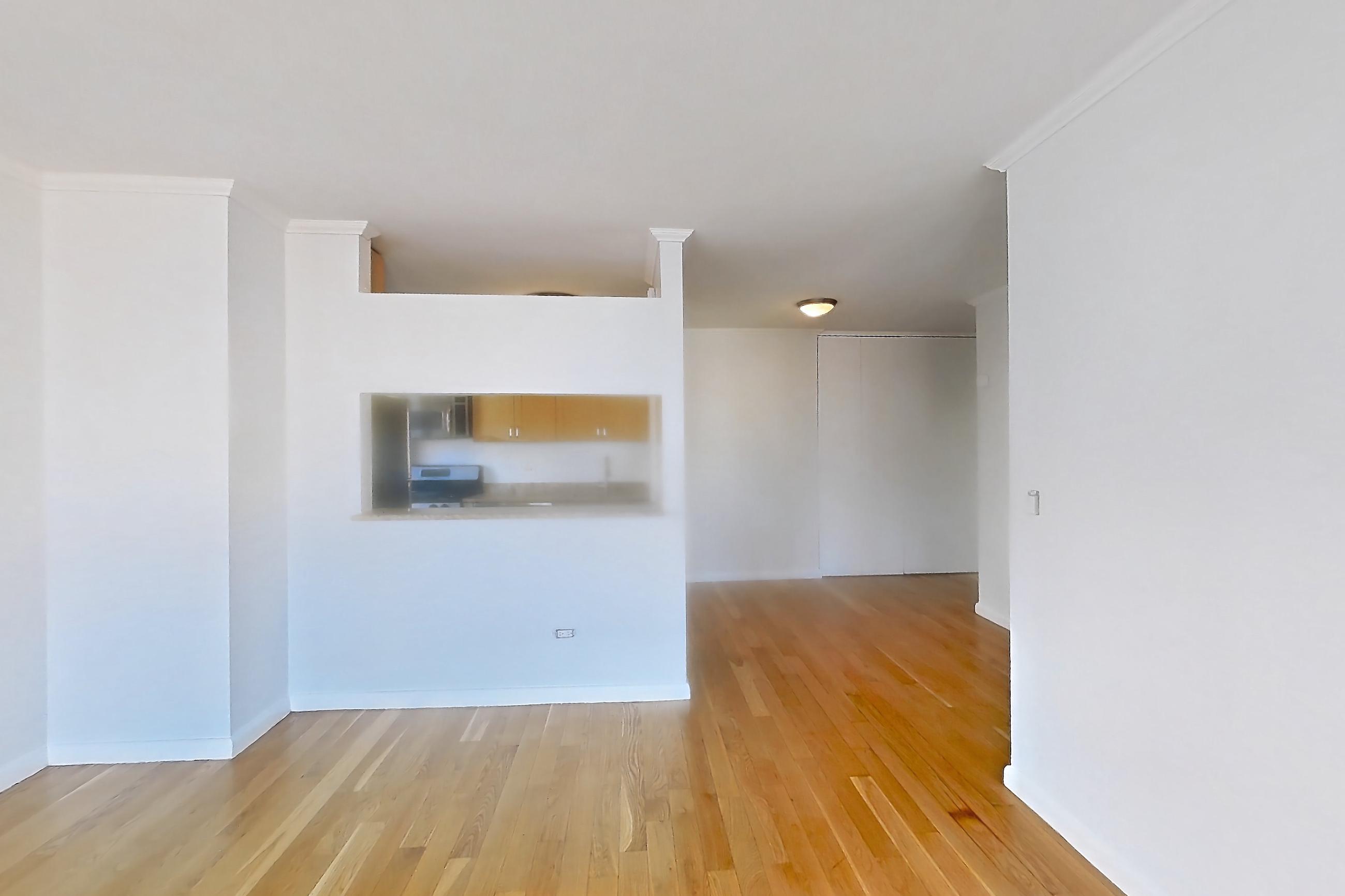 Living room with light wood-finish flooring, Apartment 36M at Stonehenge Leasing