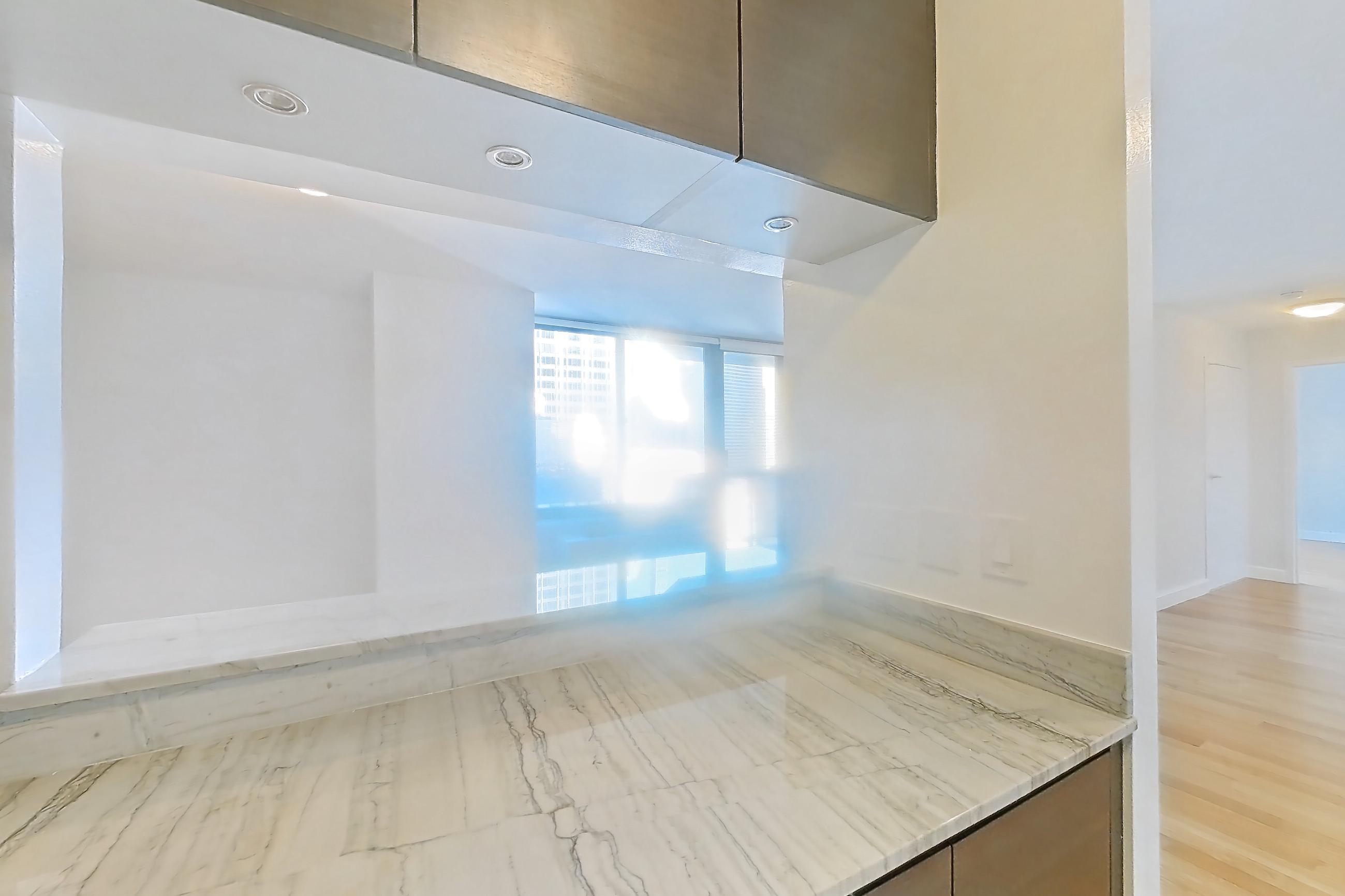 Kitchen with dishwasher, gas range, light countertops, light stone countertops, light tile flooring, light wood-finish flooring, microwave, oven/range, refrigerator, and stainless steel appliances, Apartment 28A at Stonehenge Leasing