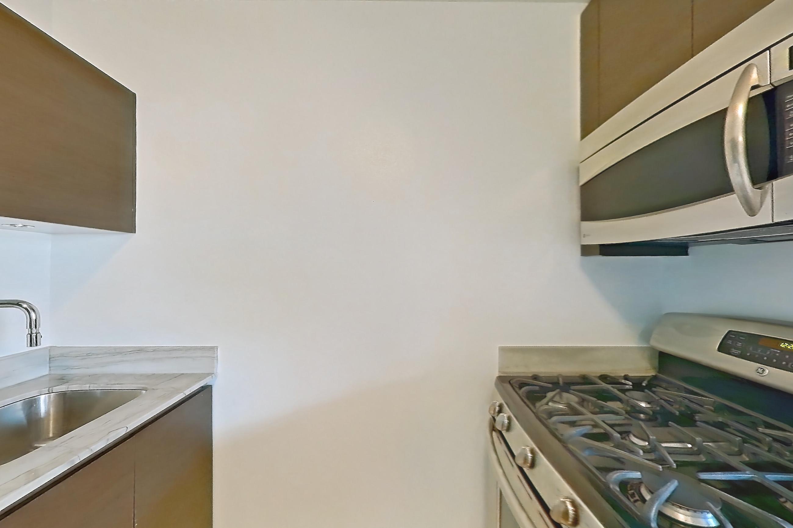 Kitchen with dishwasher, gas range, light countertops, light stone countertops, light tile flooring, light wood-finish flooring, microwave, oven/range, refrigerator, and stainless steel appliances, Apartment 28A at Stonehenge Leasing