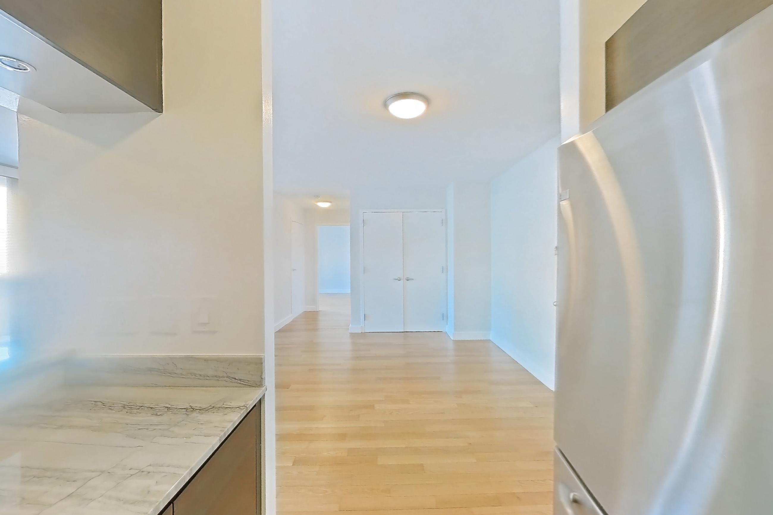 Kitchen with dishwasher, gas range, light countertops, light stone countertops, light tile flooring, light wood-finish flooring, microwave, oven/range, refrigerator, and stainless steel appliances, Apartment 28A at Stonehenge Leasing
