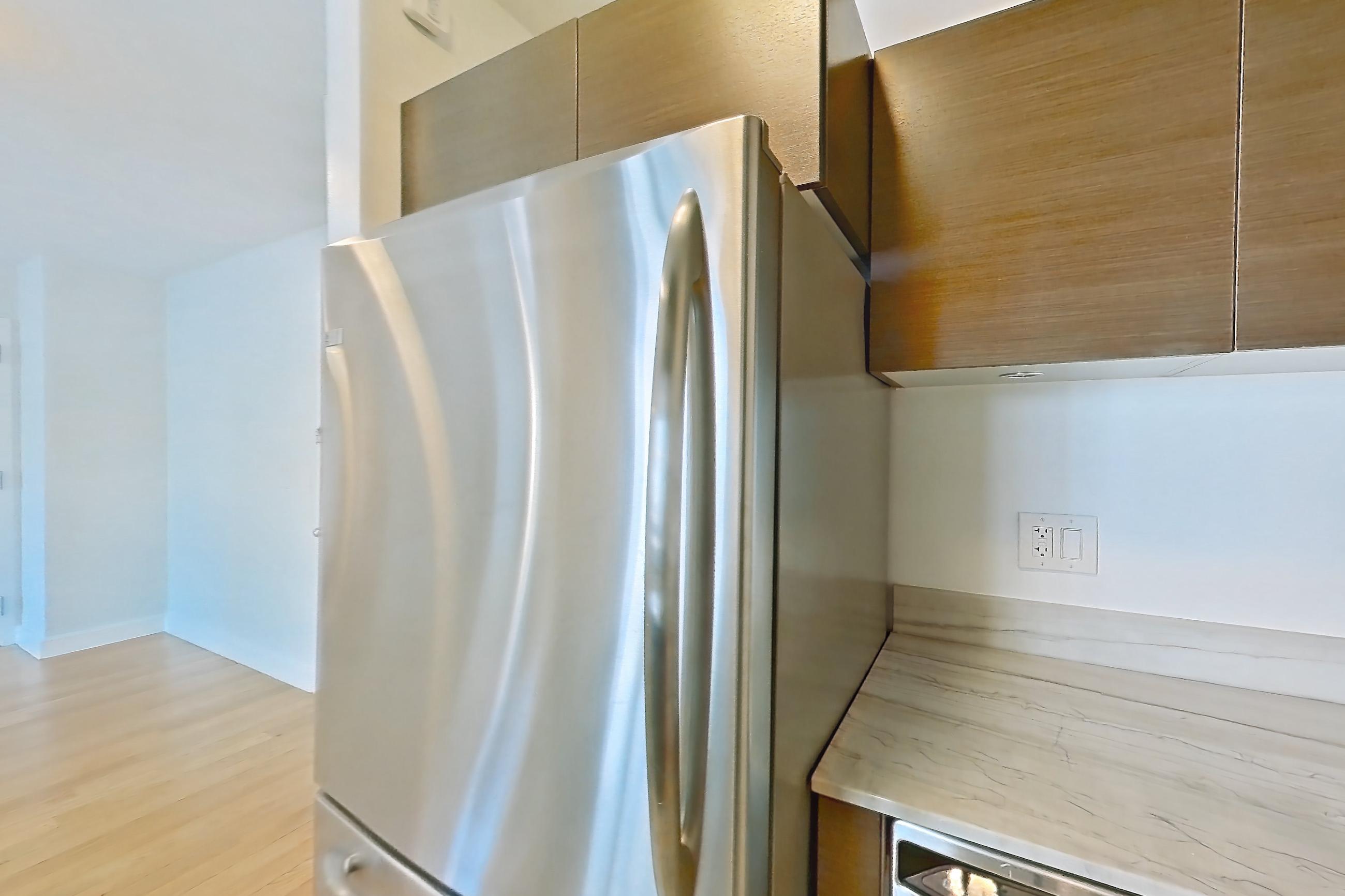 Kitchen with dishwasher, gas range, light countertops, light stone countertops, light tile flooring, light wood-finish flooring, microwave, oven/range, refrigerator, and stainless steel appliances, Apartment 28A at Stonehenge Leasing
