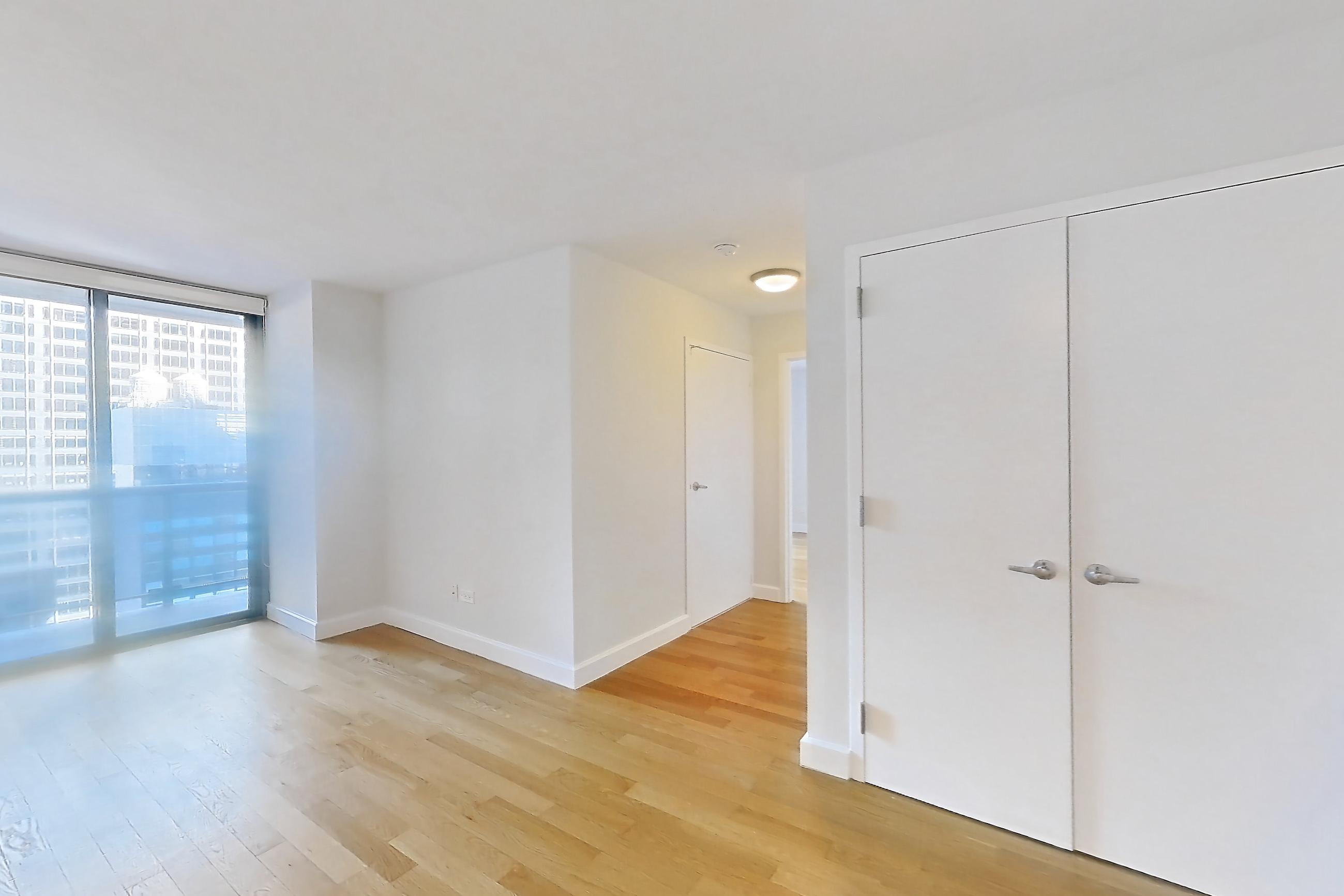 Living room with gas range, light countertops, light wood-finish flooring, oven/range, refrigerator, stainless steel appliances, and wood-finish flooring, Apartment 28A at Stonehenge Leasing