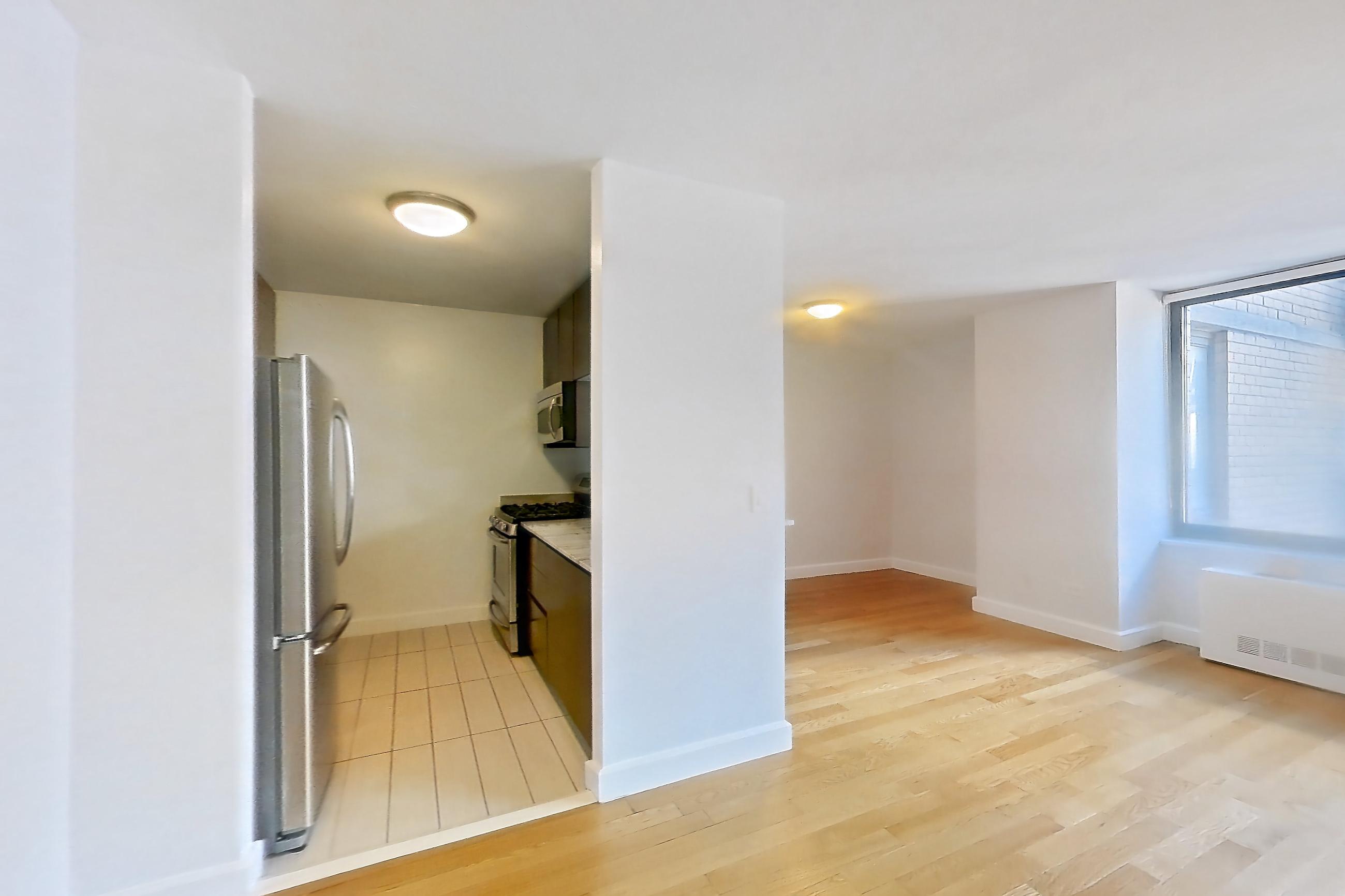 Living room with gas range, light countertops, light wood-finish flooring, oven/range, refrigerator, stainless steel appliances, and wood-finish flooring, Apartment 28A at Stonehenge Leasing