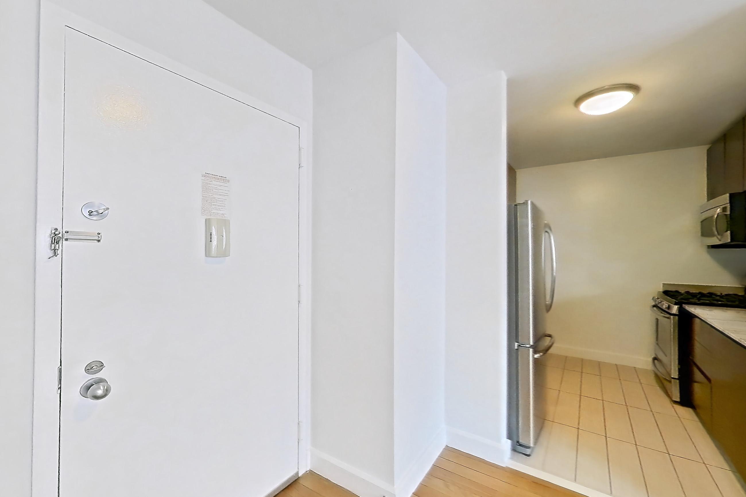 Living room with gas range, light countertops, light wood-finish flooring, oven/range, refrigerator, stainless steel appliances, and wood-finish flooring, Apartment 28A at Stonehenge Leasing