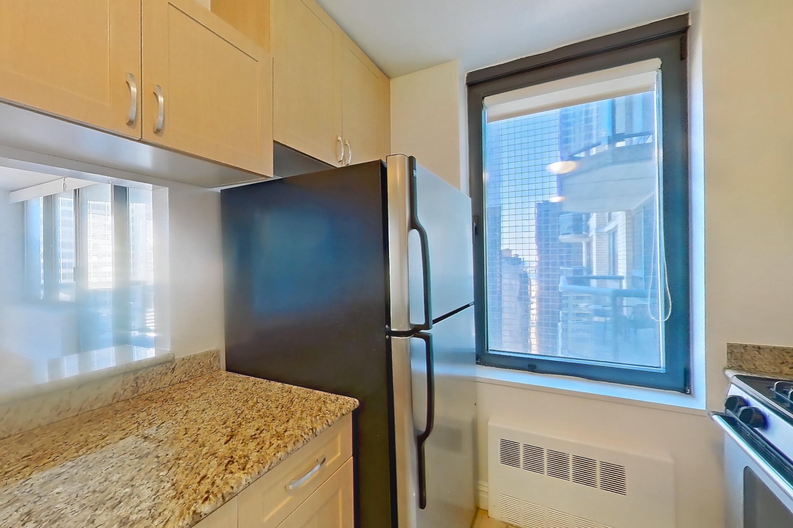 Kitchen with dishwasher, gas range, light countertops, light stone countertops, light tile flooring, microwave, oven/range, refrigerator, and stainless steel appliances, Apartment 35M at Stonehenge Leasing