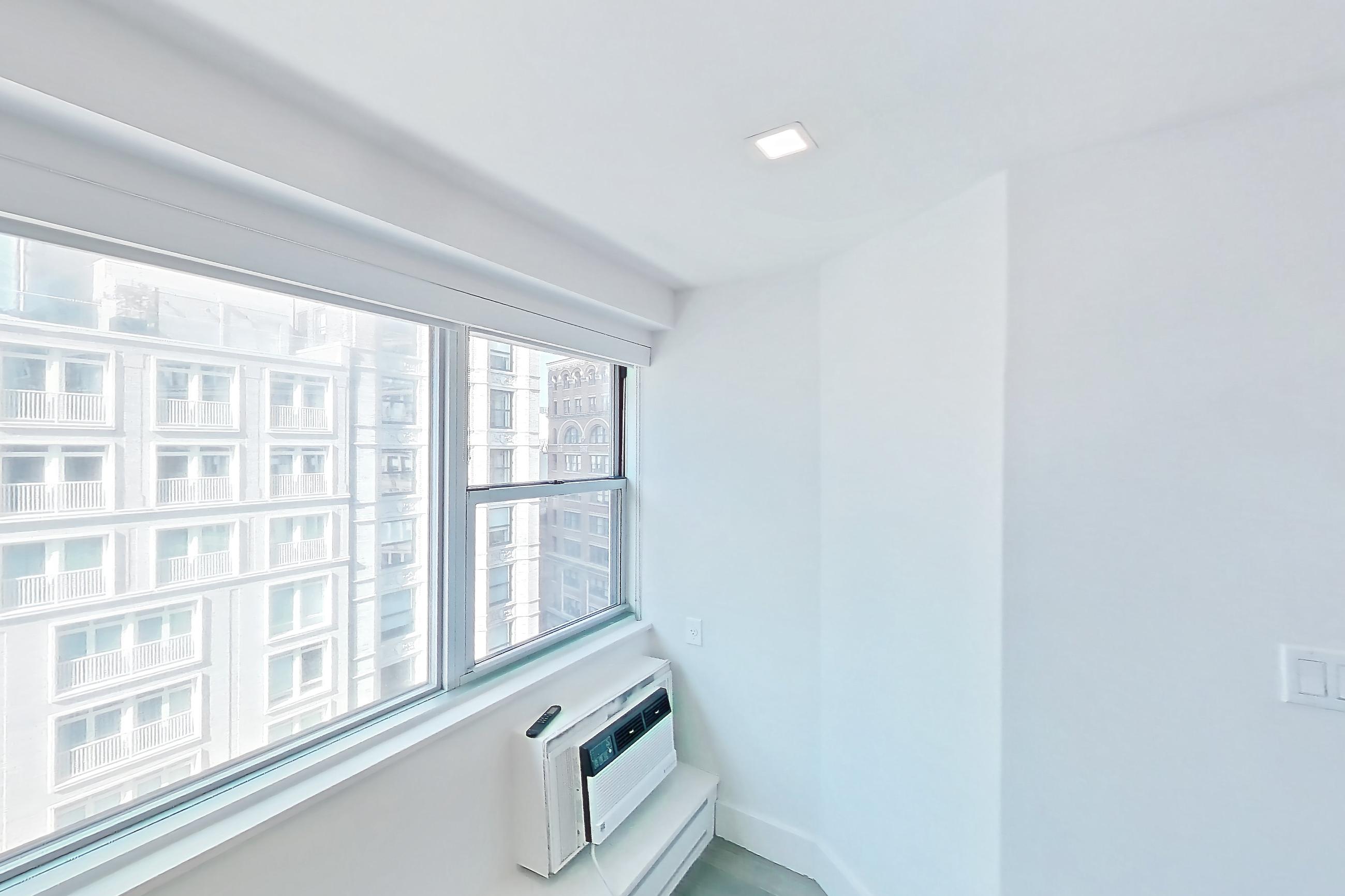Living room with air conditioning, Apartment 14D at Stonehenge Leasing