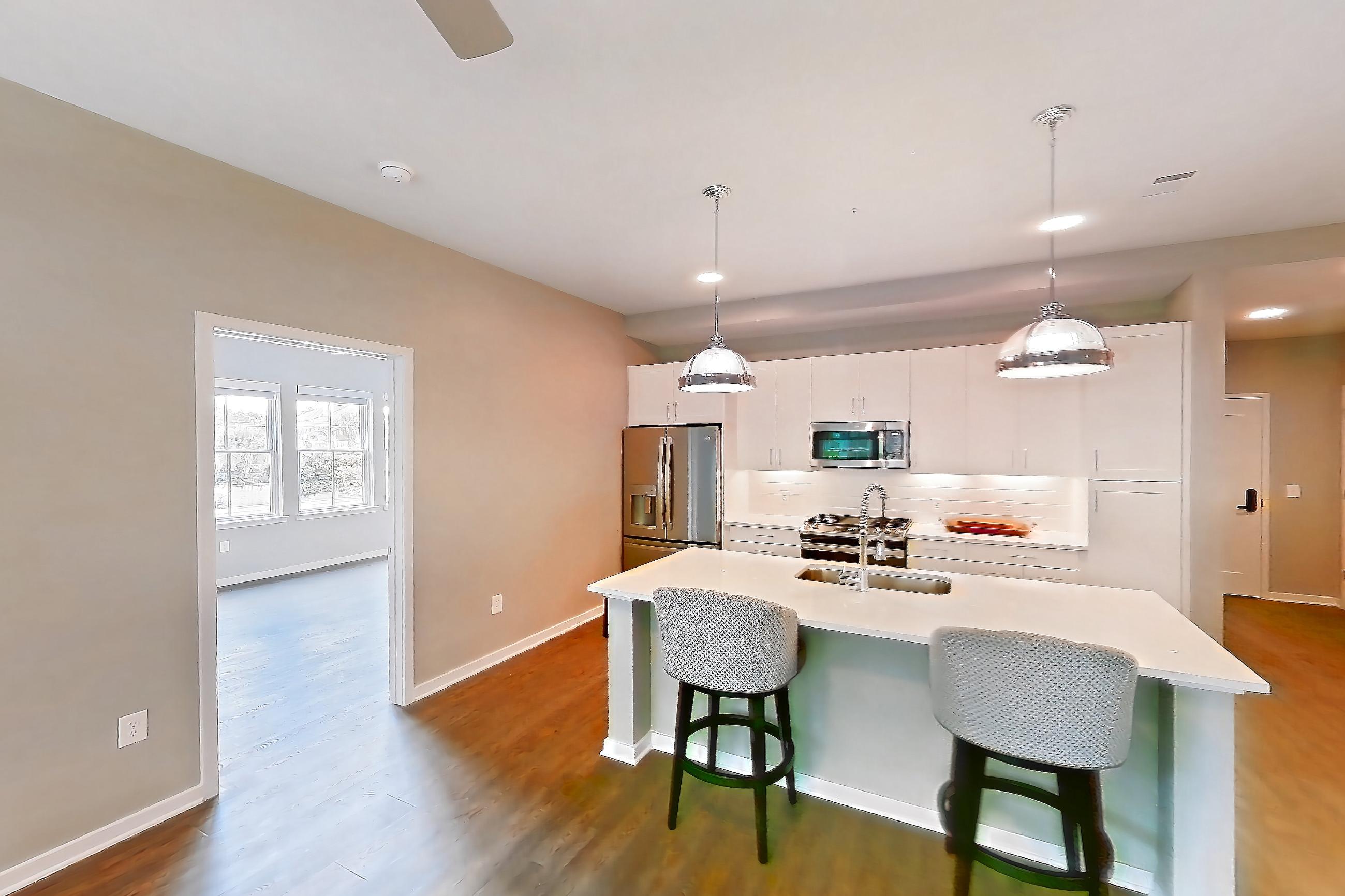 Living space with dark wood-finish flooring, gas range, kitchen island, light countertops, oven/range, refrigerator, stainless steel appliances, and water & ice dispenser, Apartment Test at Peek Content Partner Demo