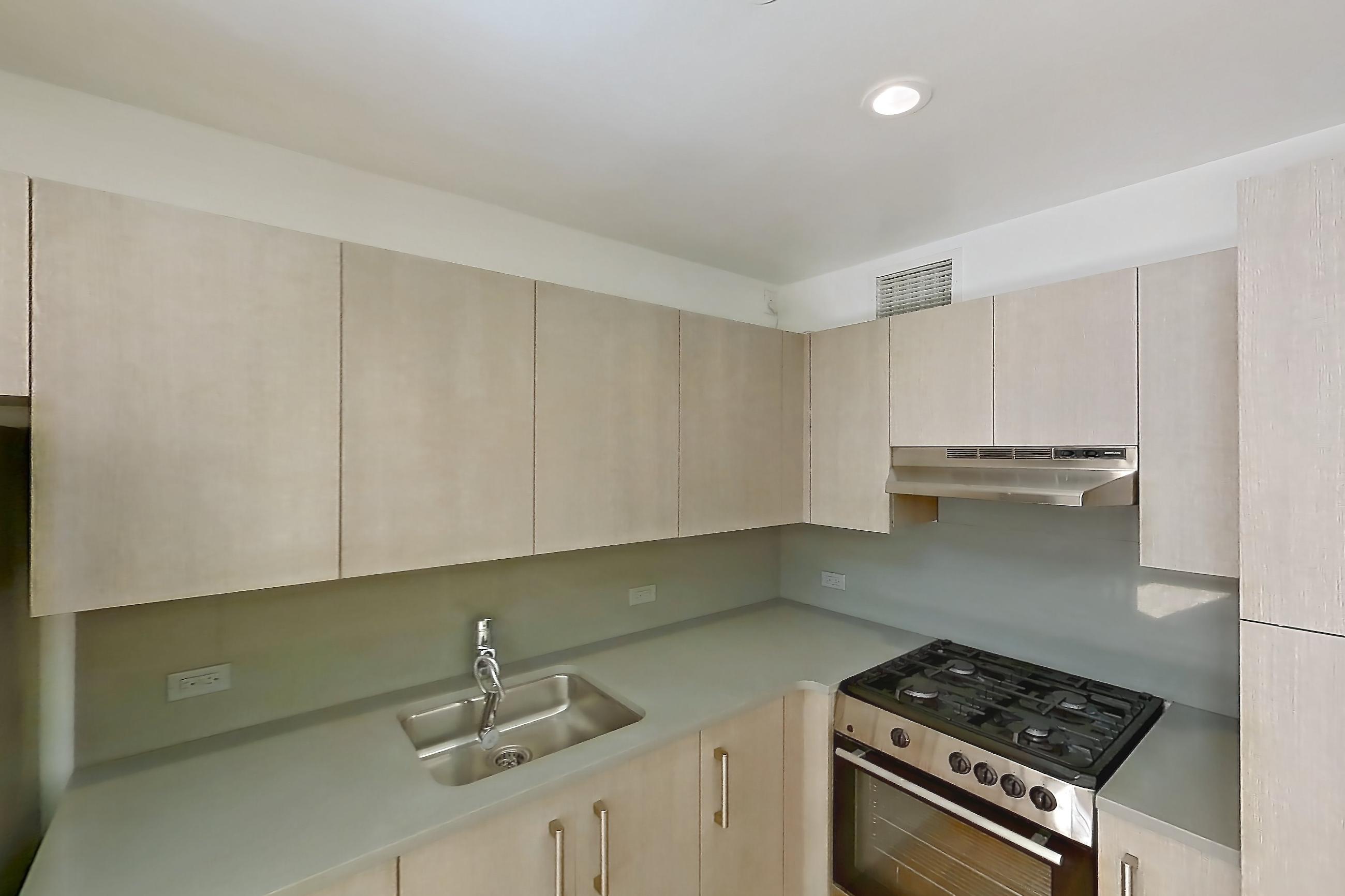 Kitchen with gas range, light countertops, light wood-finish flooring, oven/range, refrigerator, and stainless steel appliances, Apartment 110 at Stonehenge Leasing