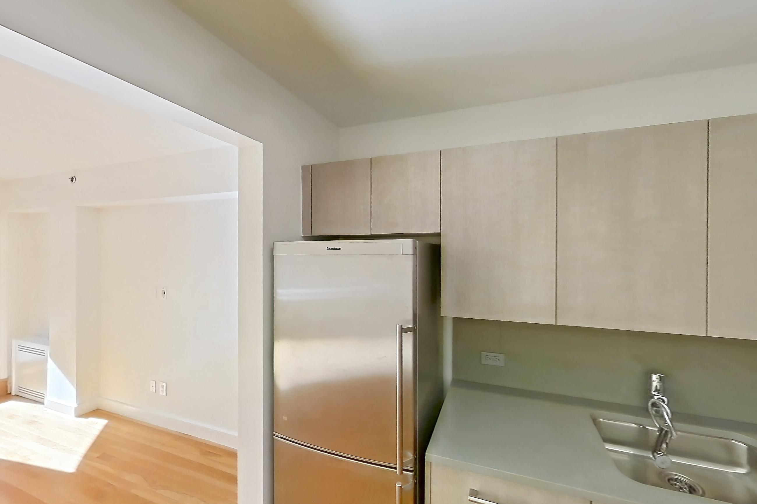 Kitchen with gas range, light countertops, light wood-finish flooring, oven/range, refrigerator, and stainless steel appliances, Apartment 110 at Stonehenge Leasing