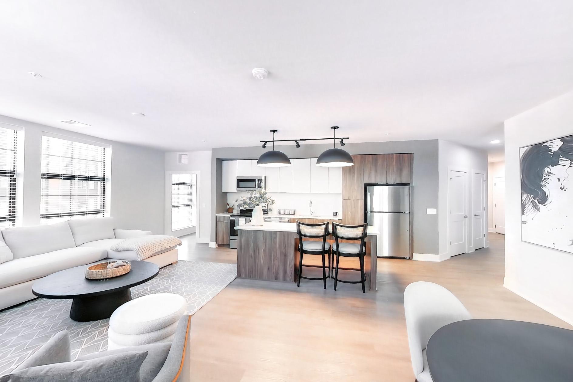 Living space corner with electric range, light wood-finish flooring, oven/range, and stainless steel appliances, Apartment L3 Model at Rye House