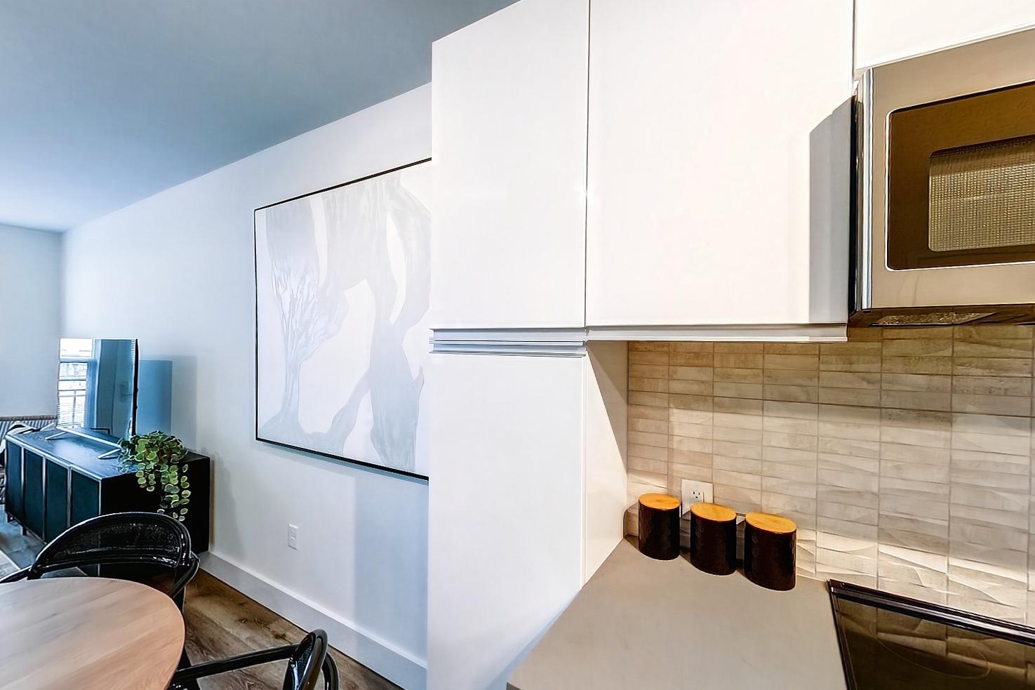 Dining room with electric range, light countertops, light stone countertops, light wood-finish flooring, microwave, oven/range, and stainless steel appliances, Apartment Model at 250 Mission