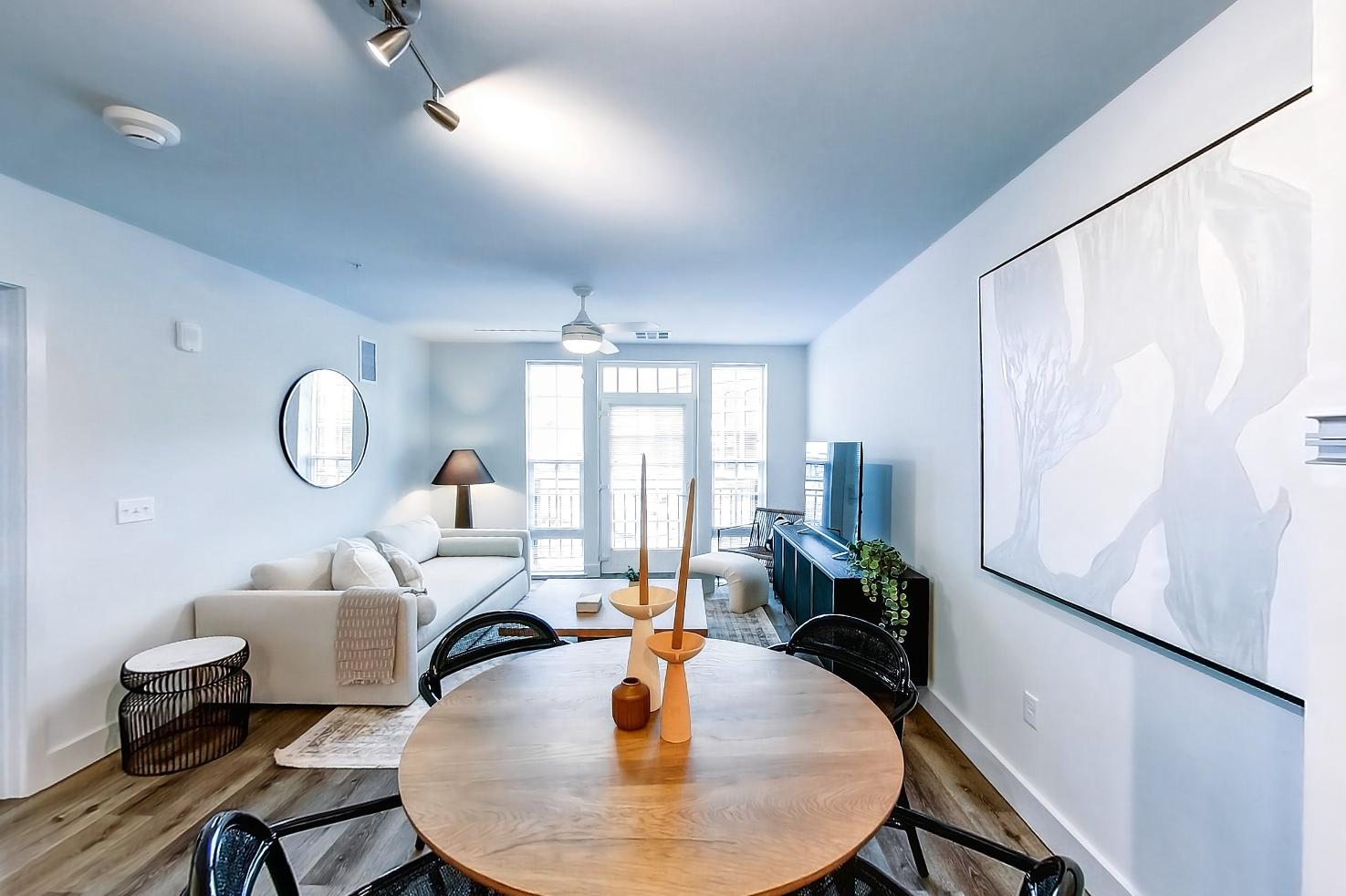 Dining room with electric range, light countertops, light stone countertops, light wood-finish flooring, microwave, oven/range, and stainless steel appliances, Apartment Model at 250 Mission