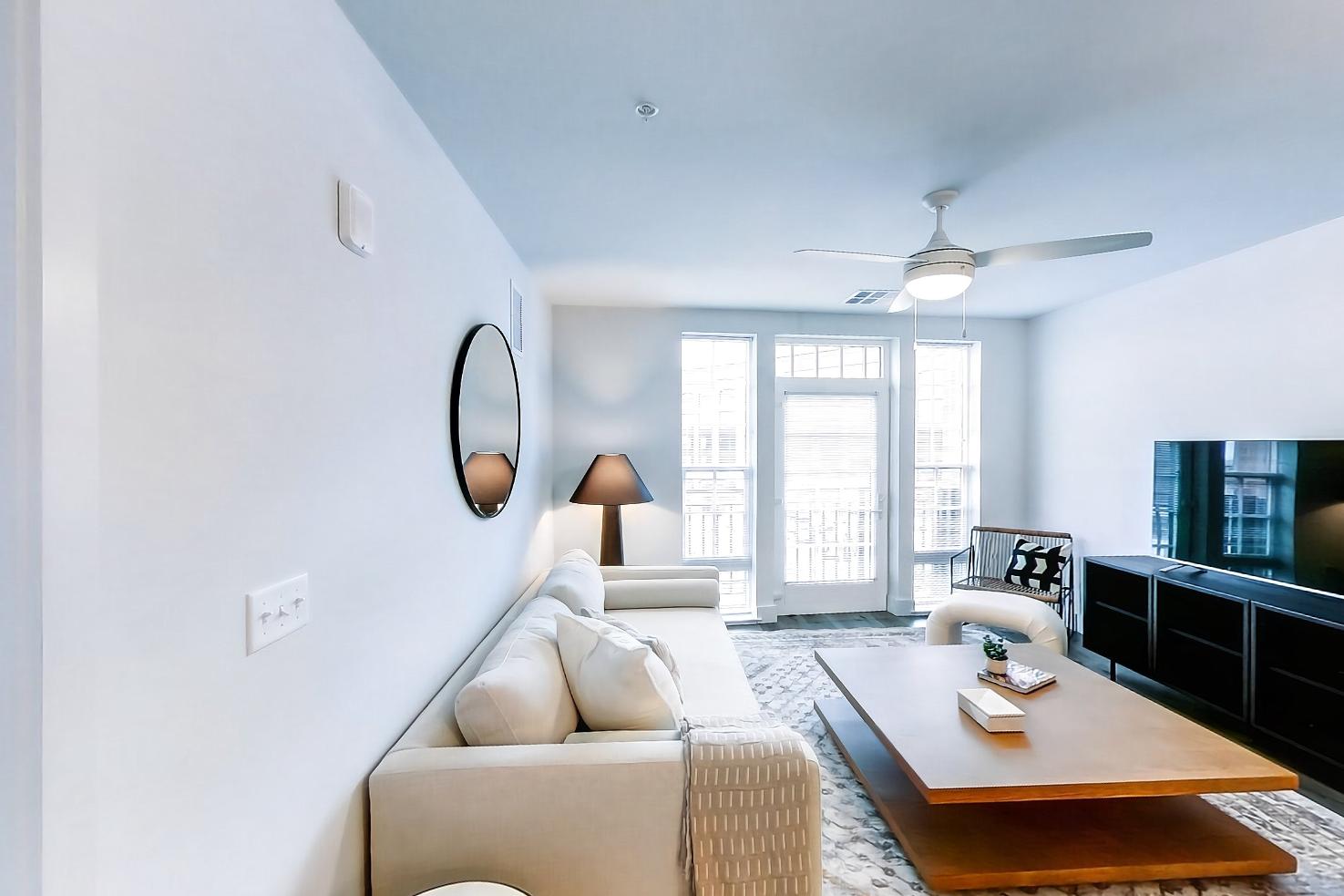 Living space with dark wood-finish flooring, electric range, light wood-finish flooring, oven/range, and stainless steel appliances, Apartment Model at 250 Mission
