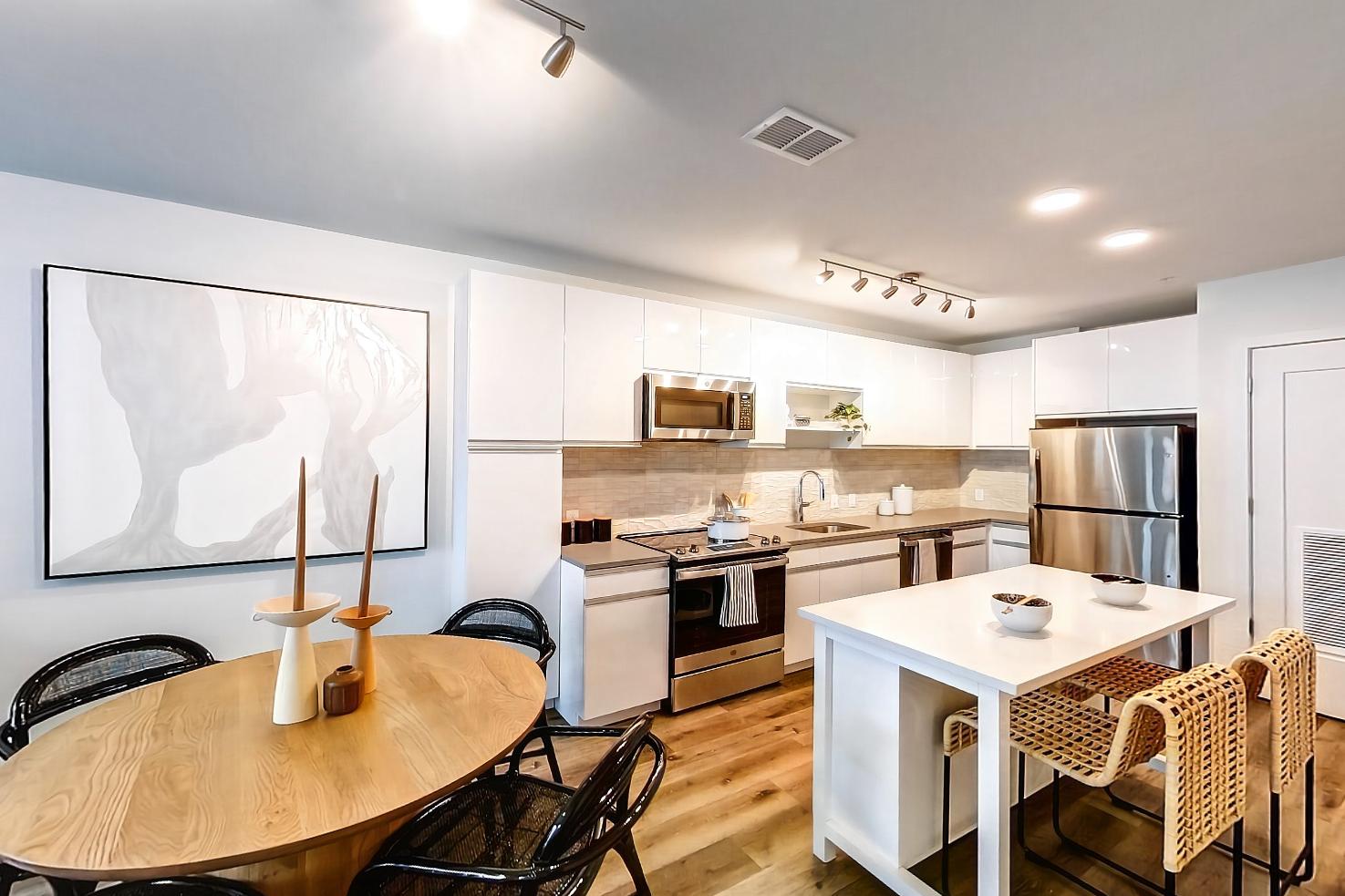 Living space with dark wood-finish flooring, electric range, light wood-finish flooring, oven/range, and stainless steel appliances, Apartment Model at 250 Mission